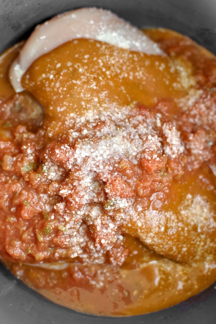 Chicken, enchilada sauce, red salsa, and salt in the bowl of an instant pot.