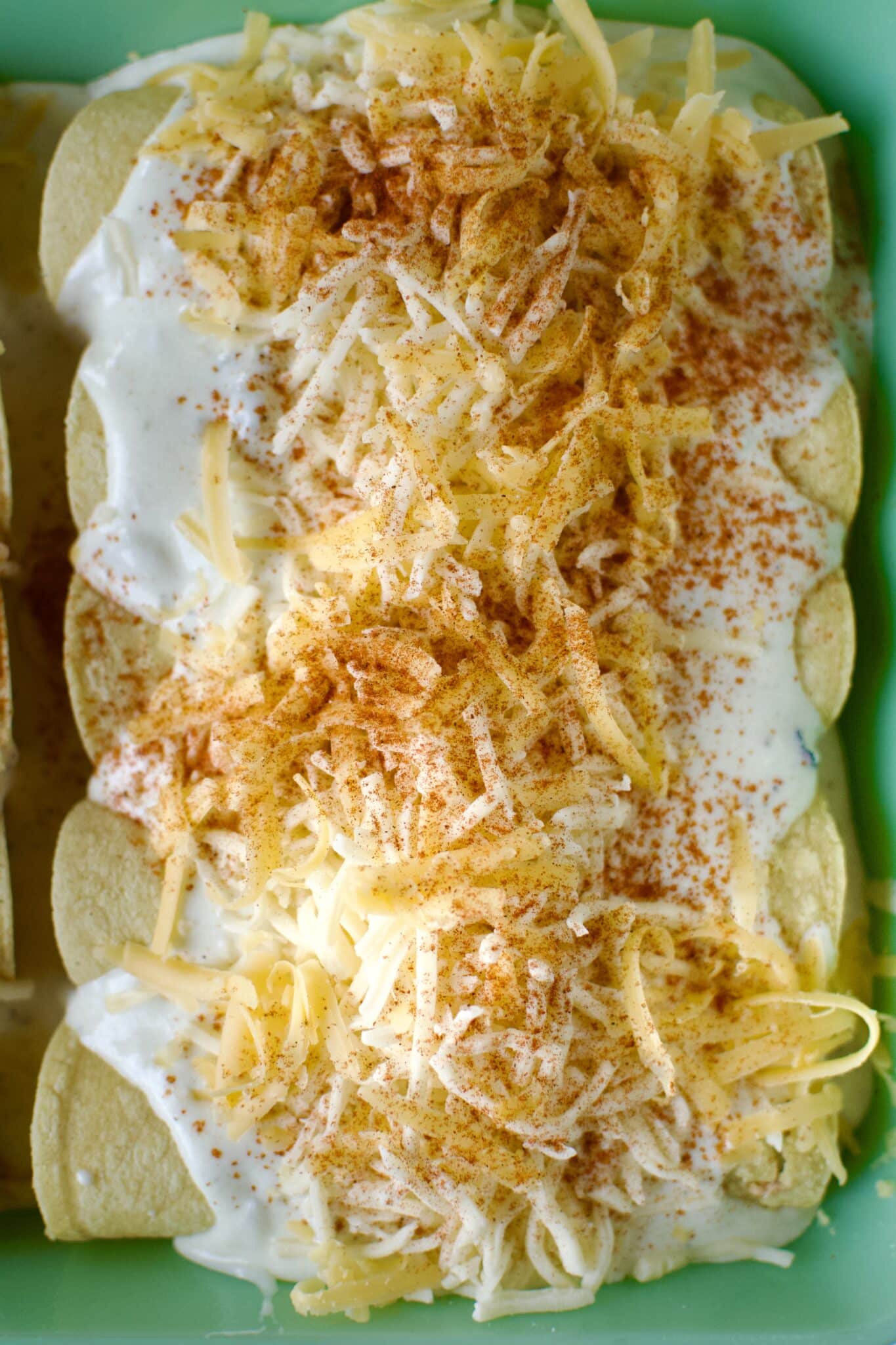 Chicken filled tortillas rolled up and placed in a baking dish that has been lined with sour cream enchilada sauce. Then topped with more sauce and cheese before baking.