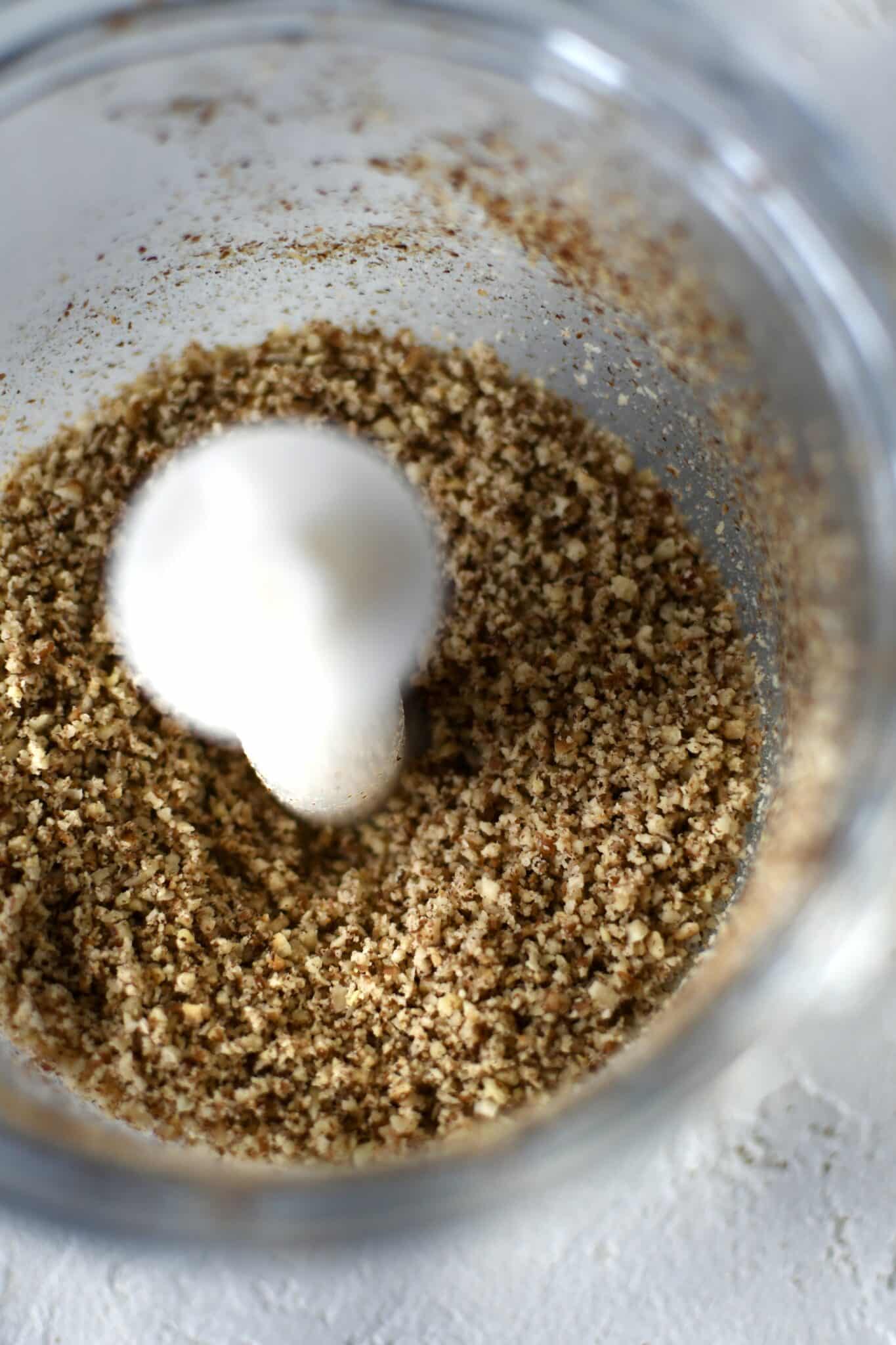 Finely ground pecan in a mini food processor.