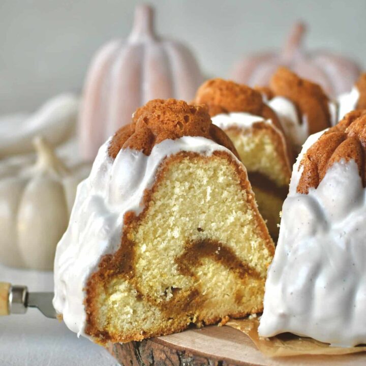 Pumpkin Pound Cake with a slice being removed from the bundt that looks like pumpkins in a field.
