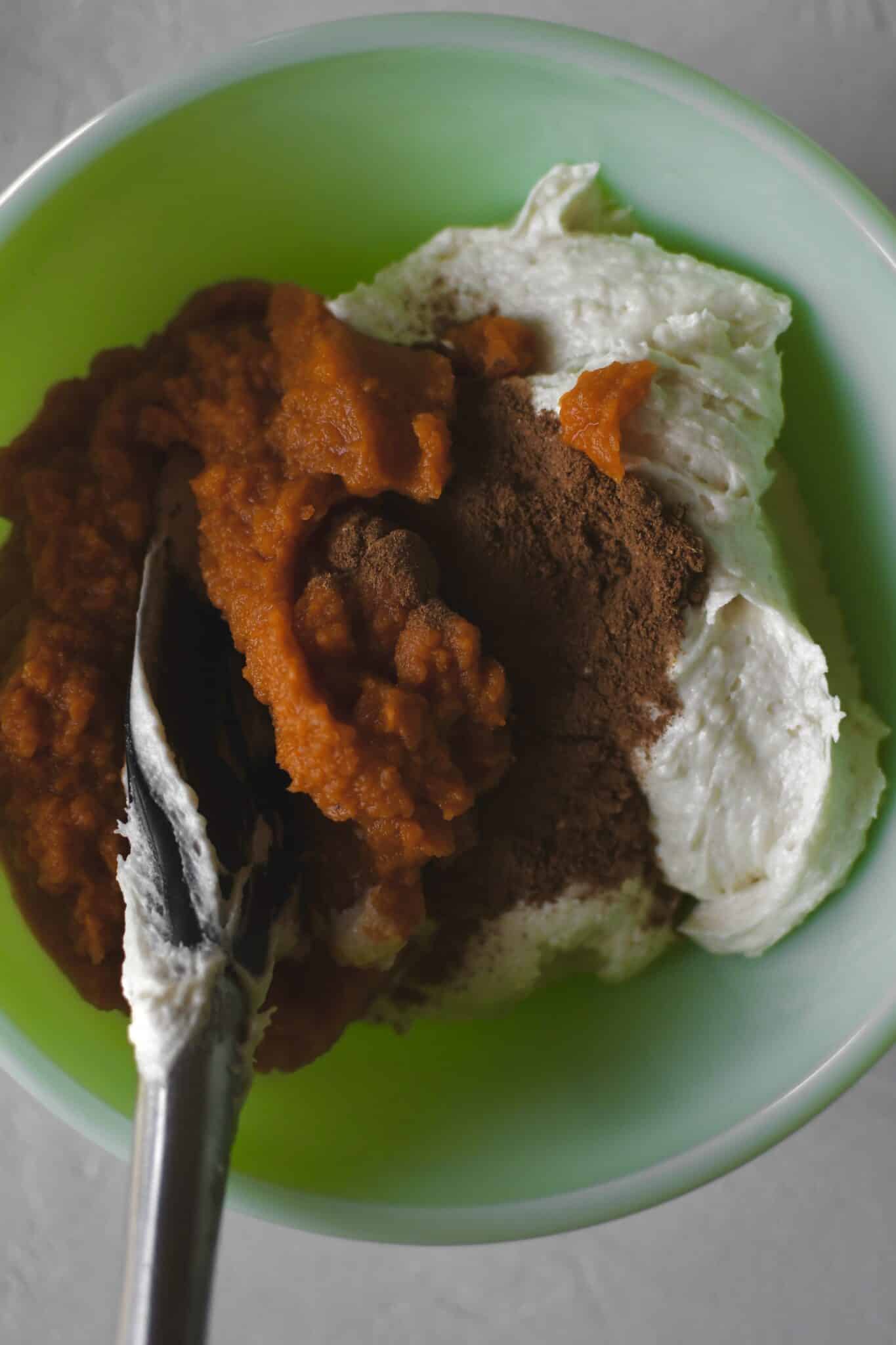 Some pound cake batter removed to a secondary bowl, folding in the pumpin and spices.