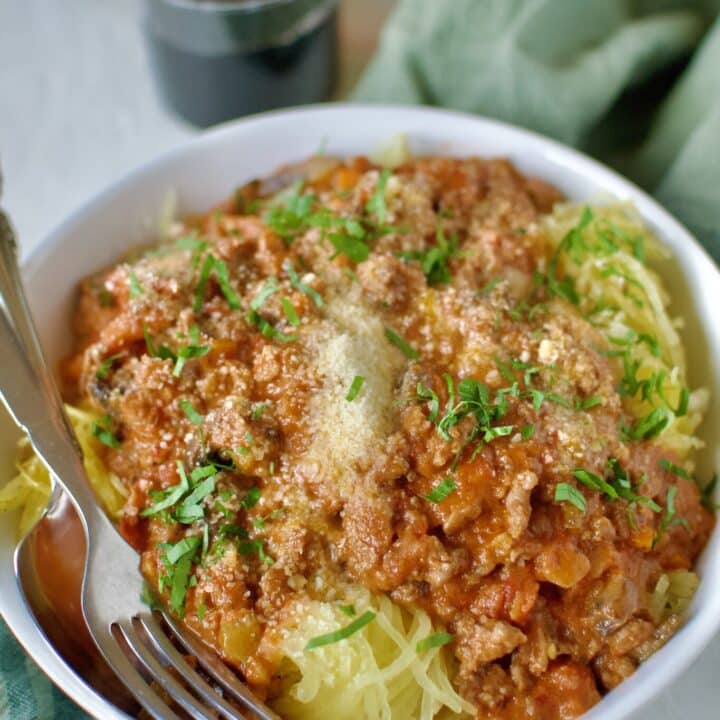 Sausage Bolognese served over roasted spaghetti squash and topped with parmesan cheese and basil.