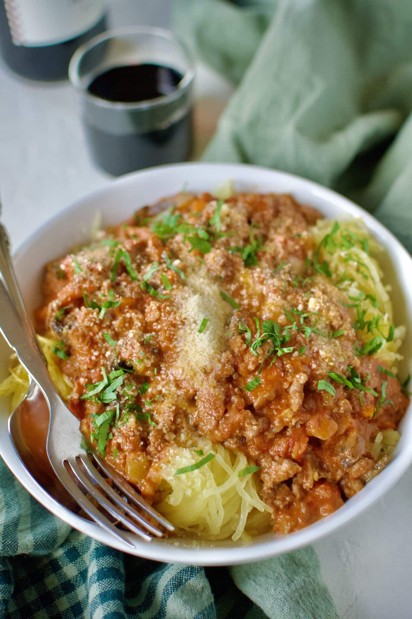 Sausage Bolognese served over roasted spaghetti squash and topped with parmesan cheese and basil.