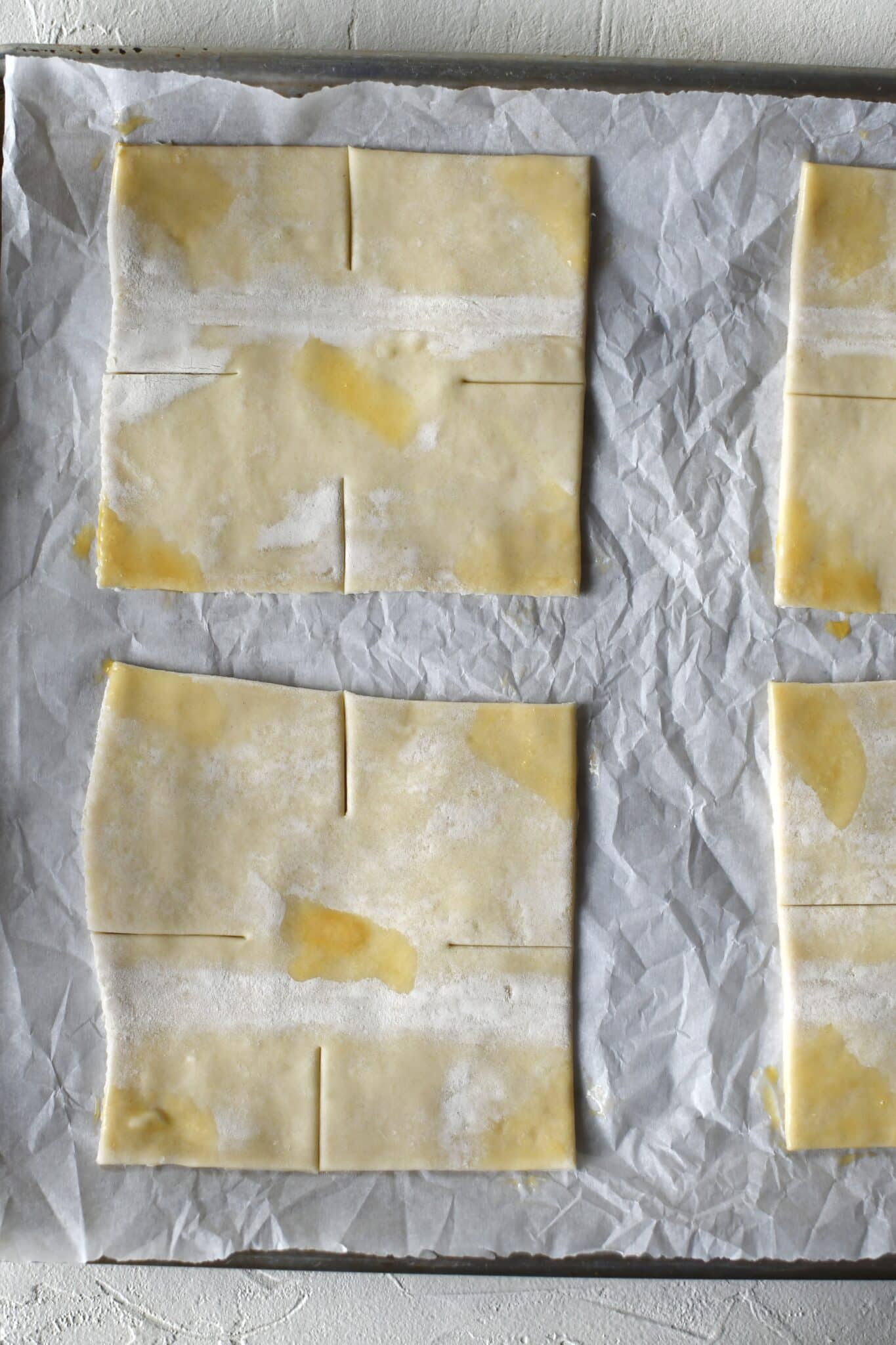 Puff pastry, portioned and cut with some egg wash in spots for folding to stick together.