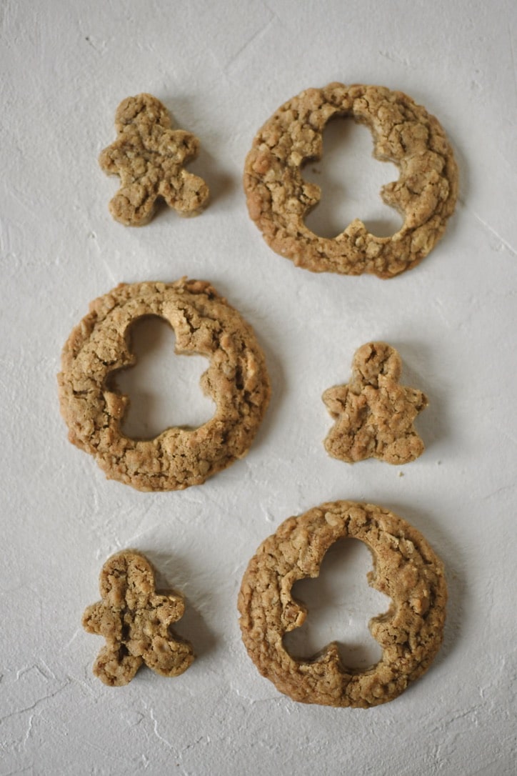 Gingerbread oatmeal cookies with gingerbread men shapes cut out of them.