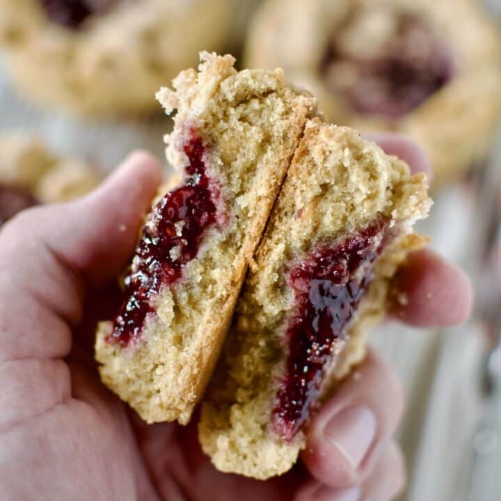 A Peanut Butter and Jelly Cookie broken in half in a hand.