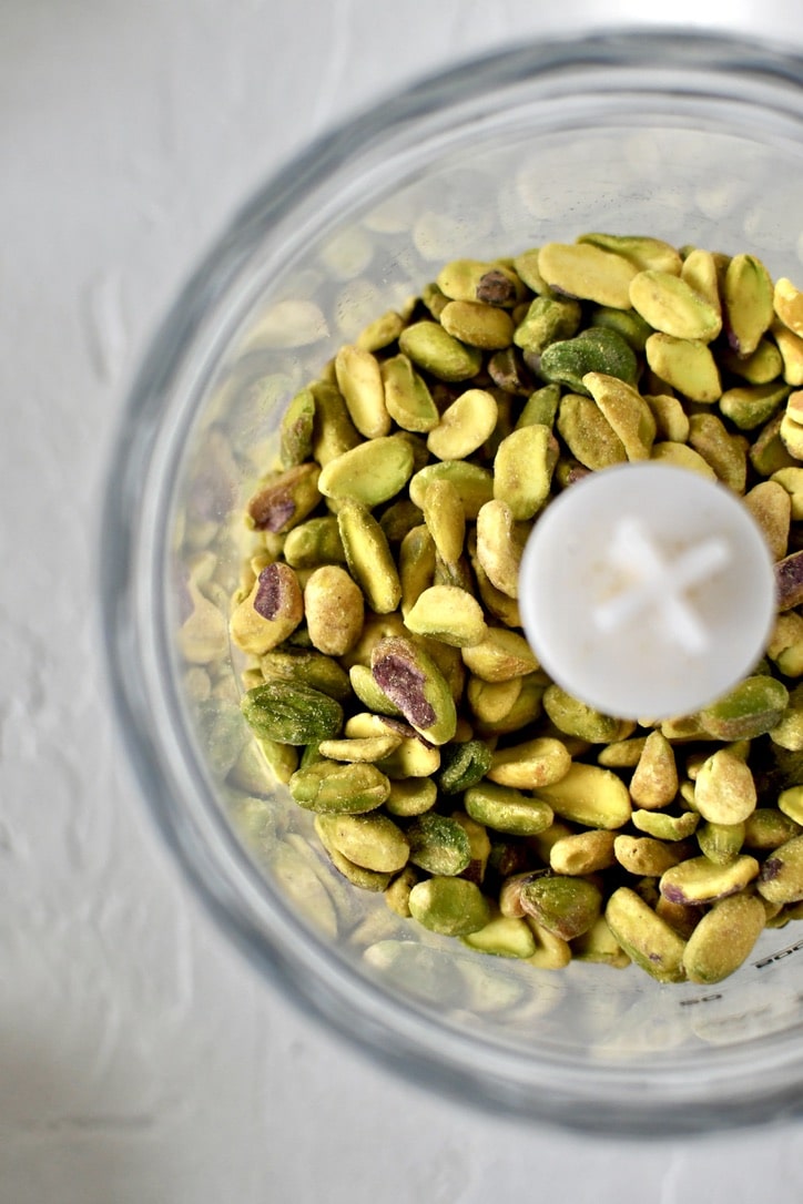 Pistachio nuts in a food processor before blending.