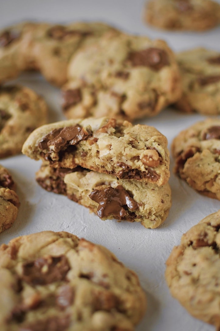 Kitchen Sink Cookies on a board, with one in the middle broken in half.