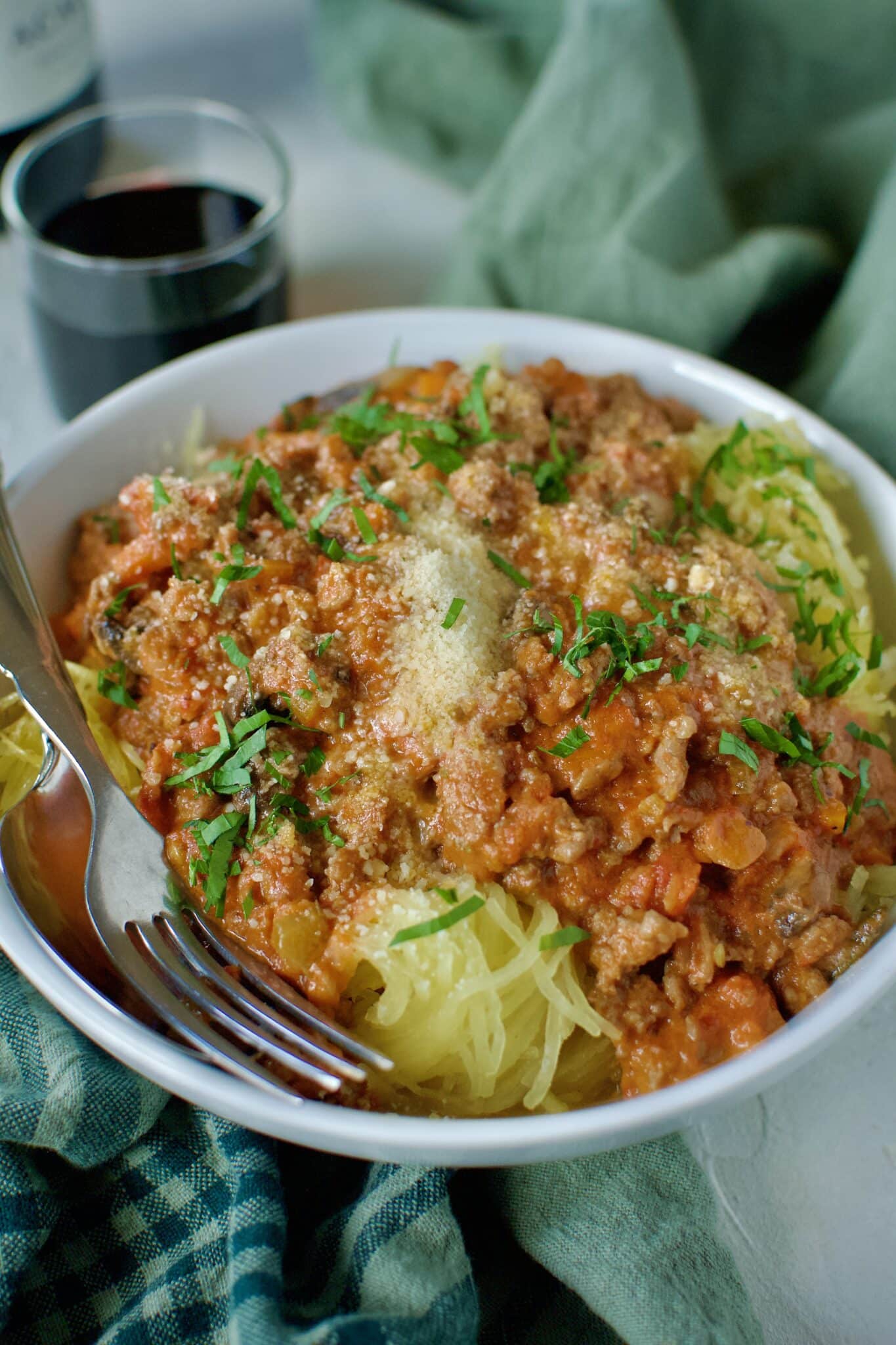Sausage Bolognese served over roasted spaghetti squash and topped with parmesan cheese and basil.