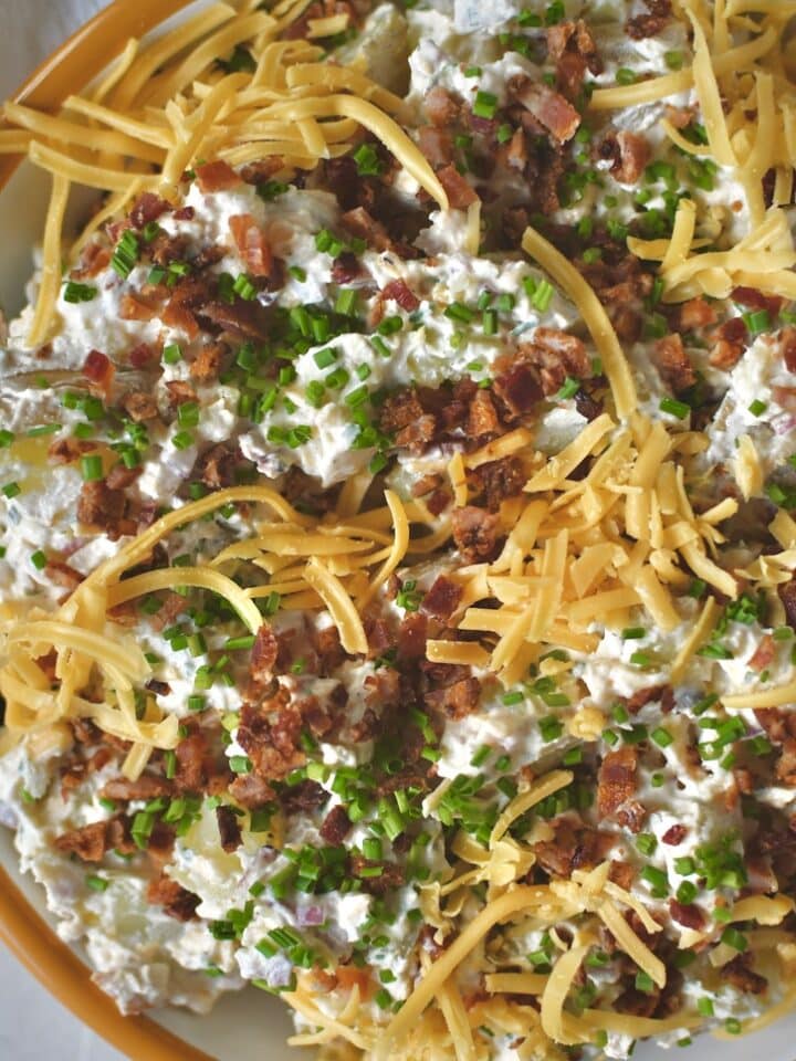 Ranch Potato Salad in a bowl topped with chives, bacon, and cheddar, ready to eat!