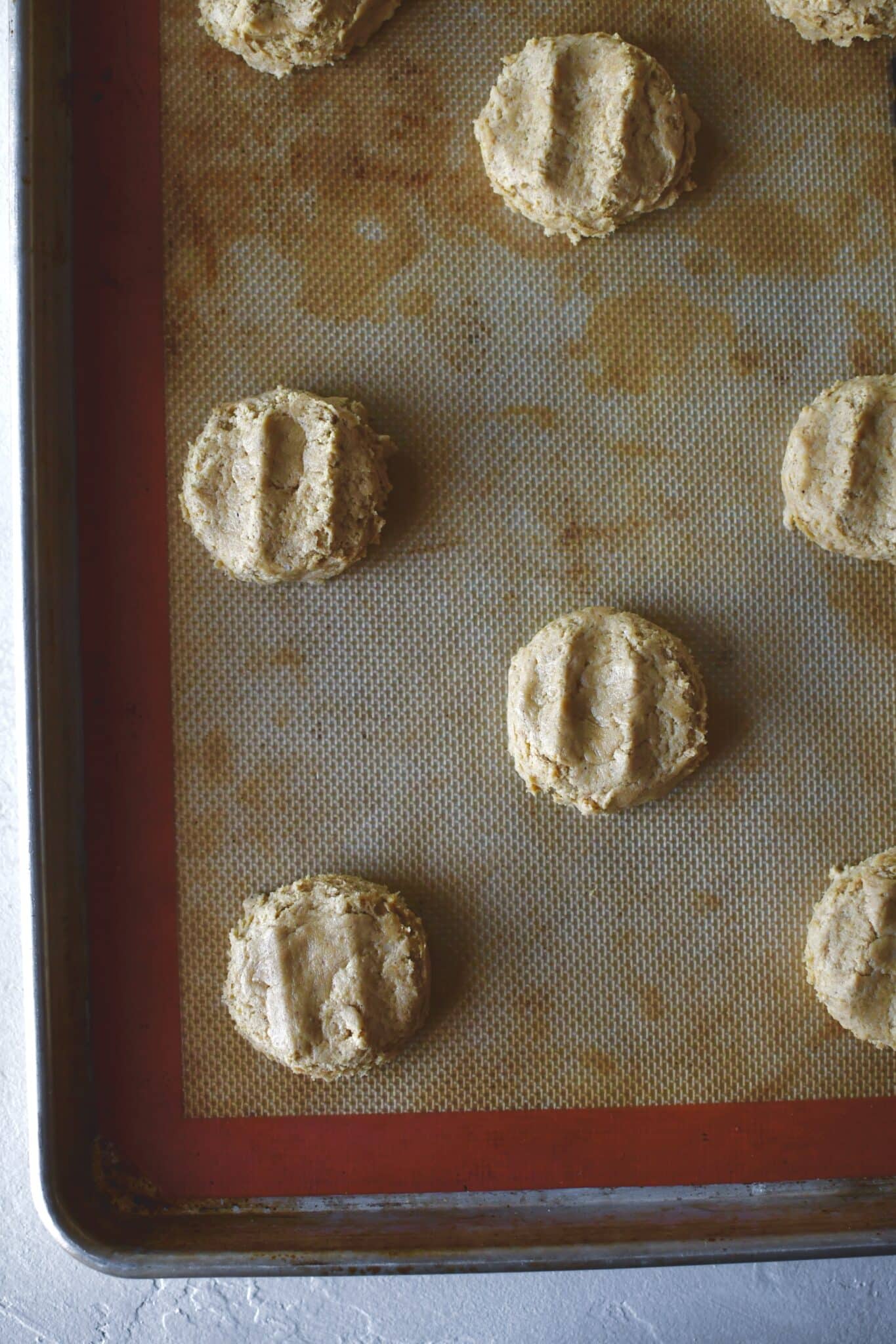 Whoopie pies portioned on a sheet pan and lightly pressed down, before baking.