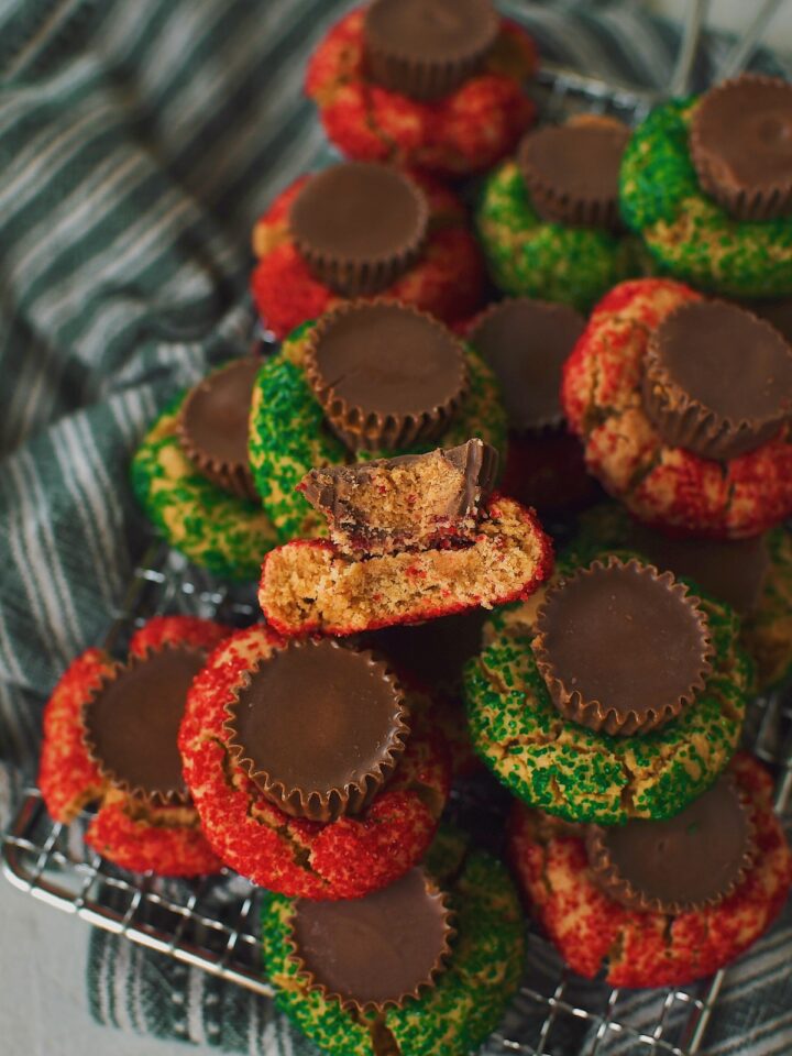 A tray of peanut butter cup cookies, on in the middle has a bite taken from it.