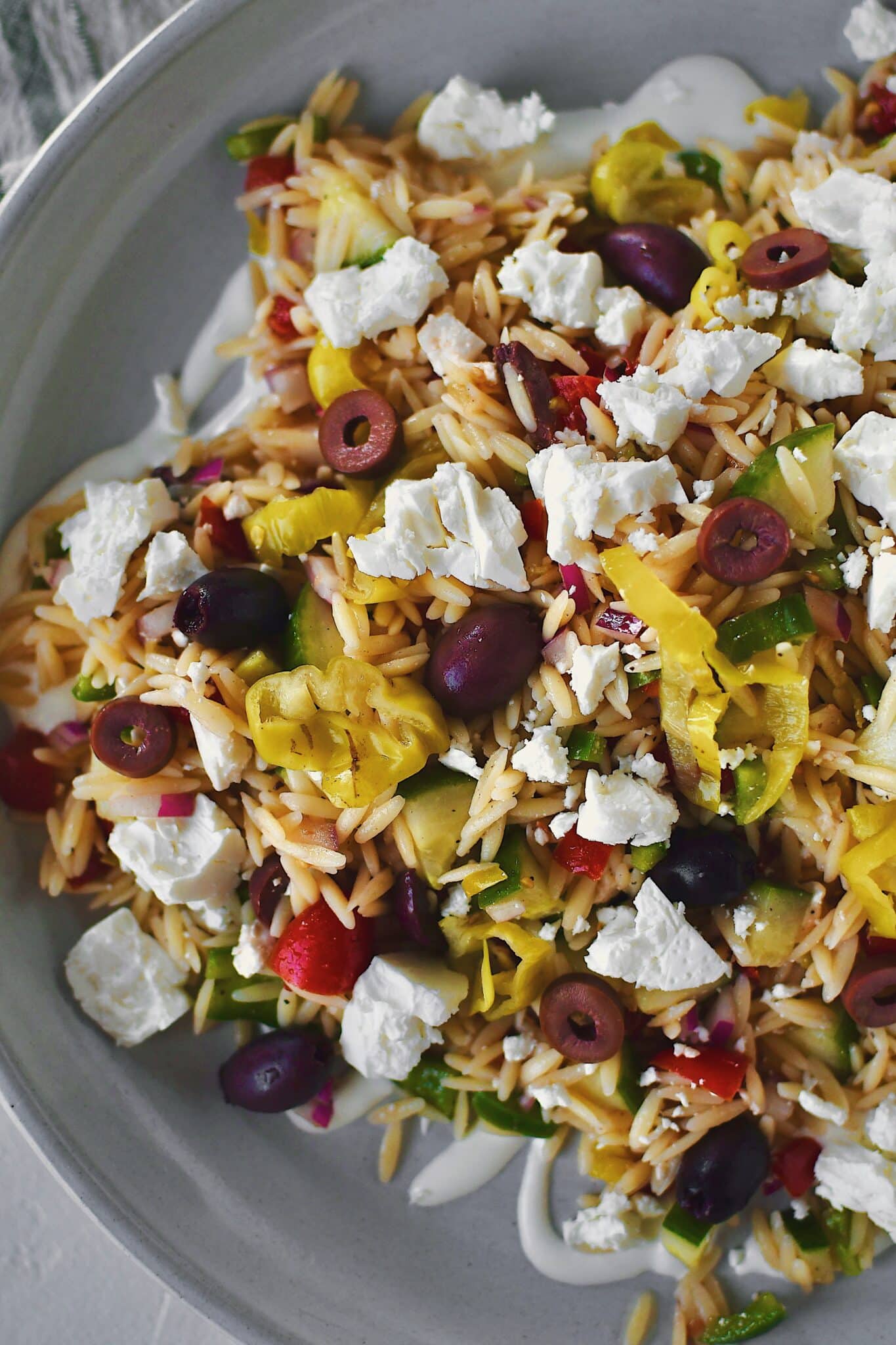 Greek Pasta Salad on a platter, topped with extra feta, ready to be enjoyed!