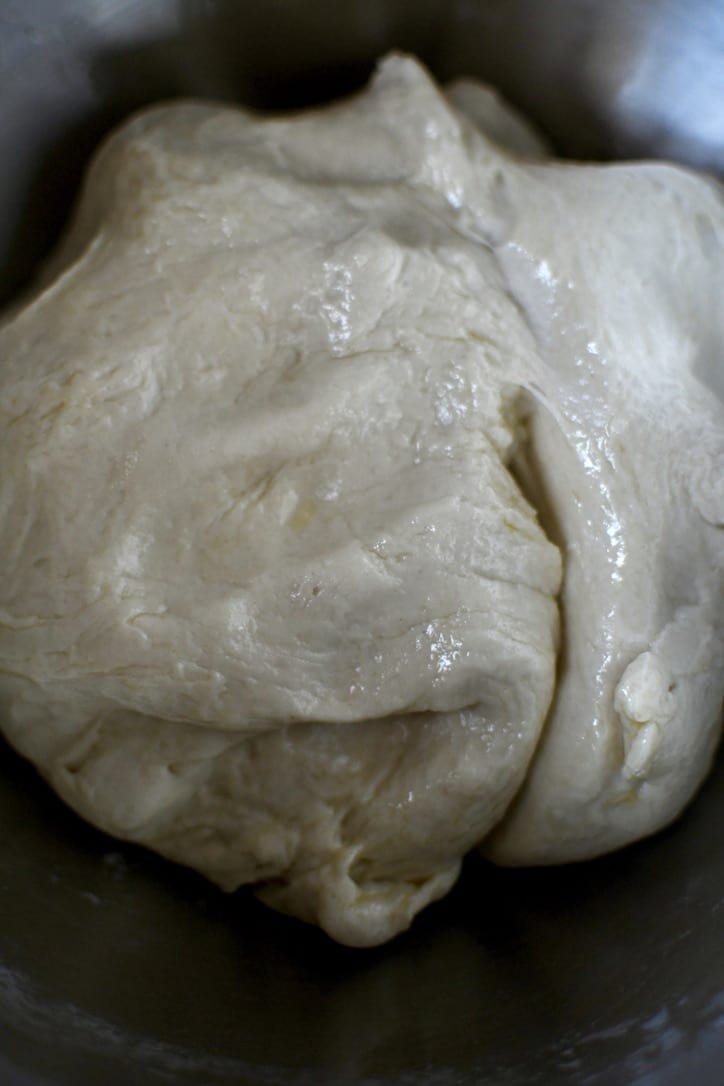 Fully kneaded dough that has been oil in a bowl ready to be rested and risen.