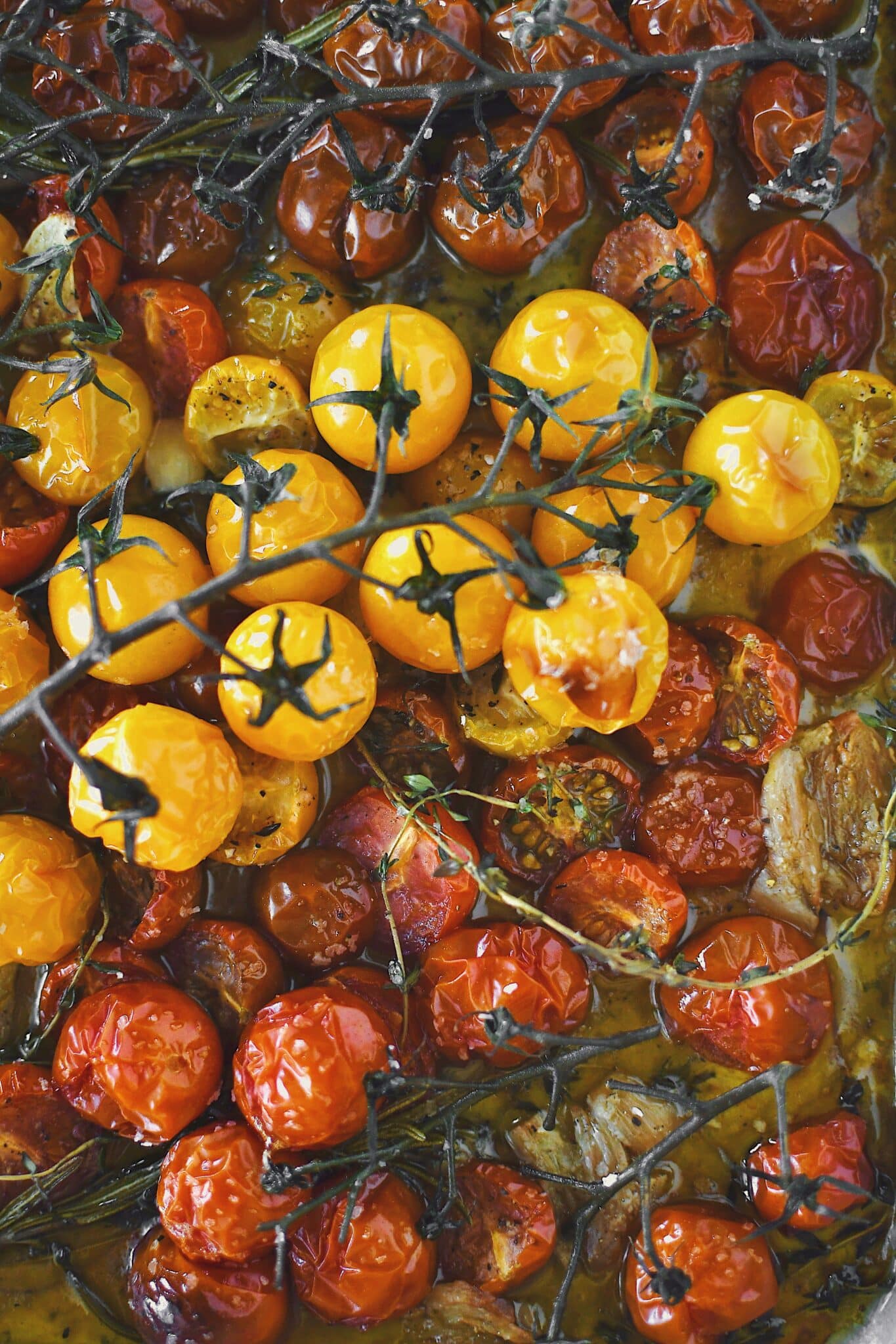 Seasoned cherry tomatoes, garlic, and herbs, after roasting.