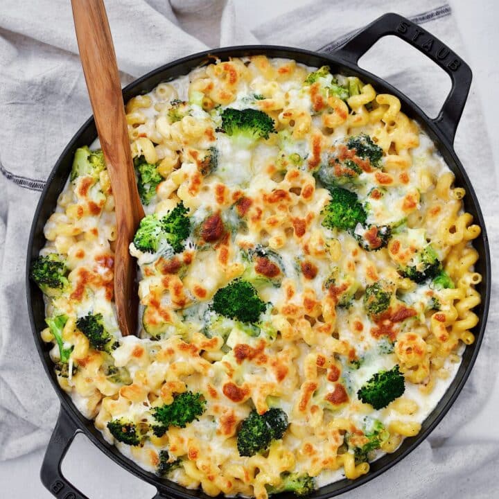 Alfredo Broccoli Pasta in the baking dish after baking to golden brown, spooning some out.