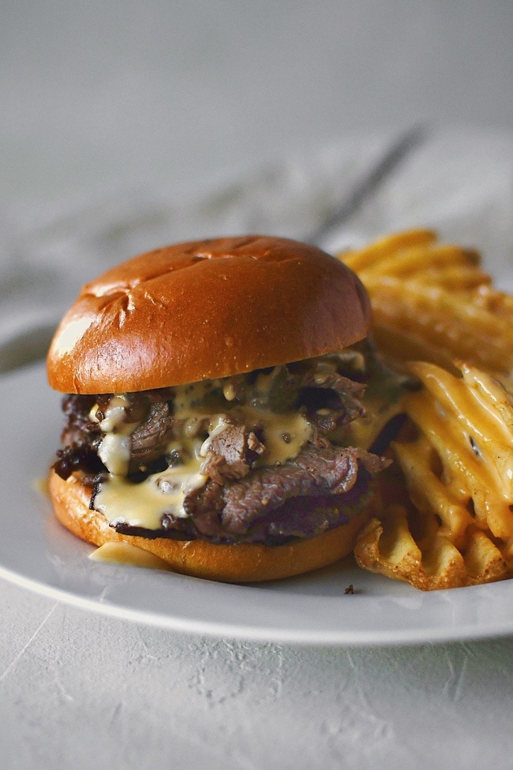 Warm roast beef sandwich topped with cheddar cheese sauce and served with waffle fries.