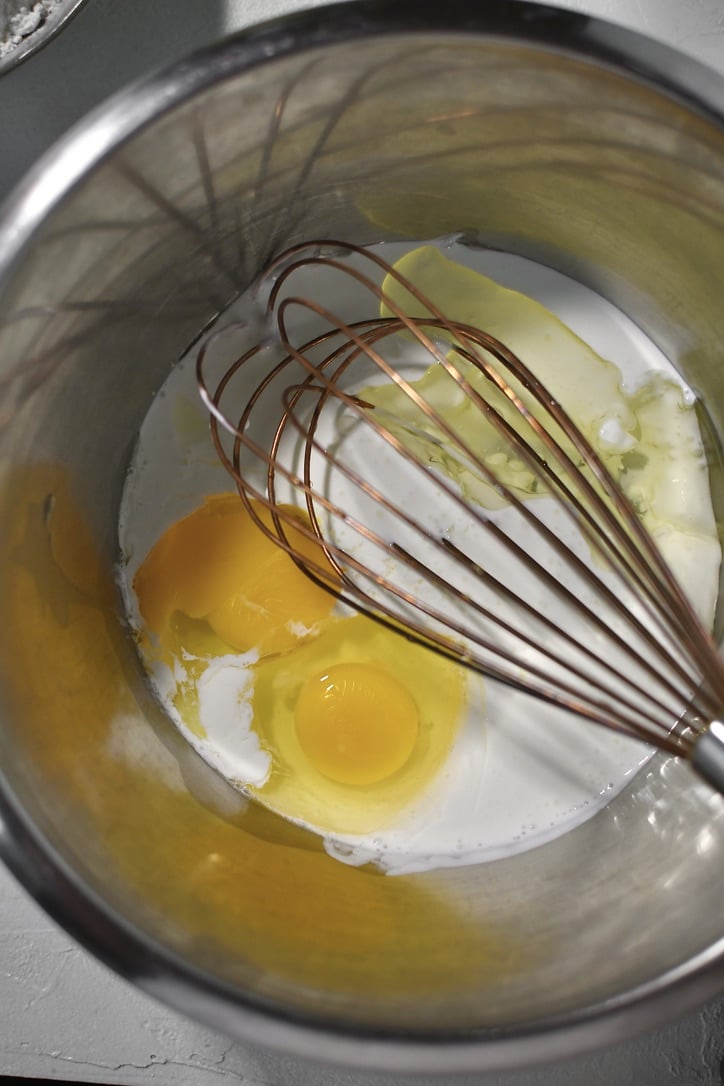 Milk, eggs, and oil in a bowl ready to be whisked.