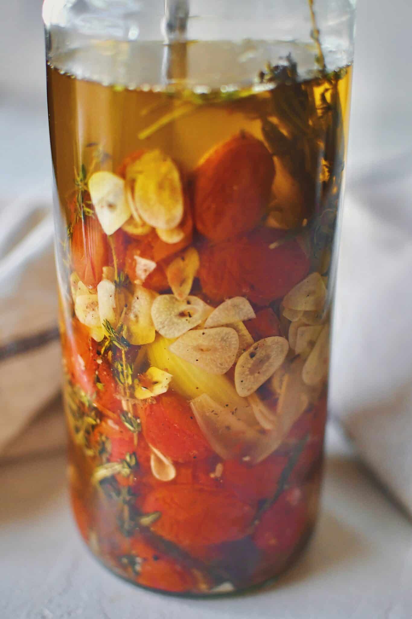 Tomato Confit in a jar covered in oil, ready to be stored.