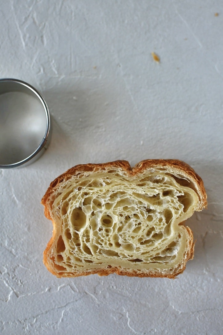 Croissant Toast on a work surface with a round cutter next to it.