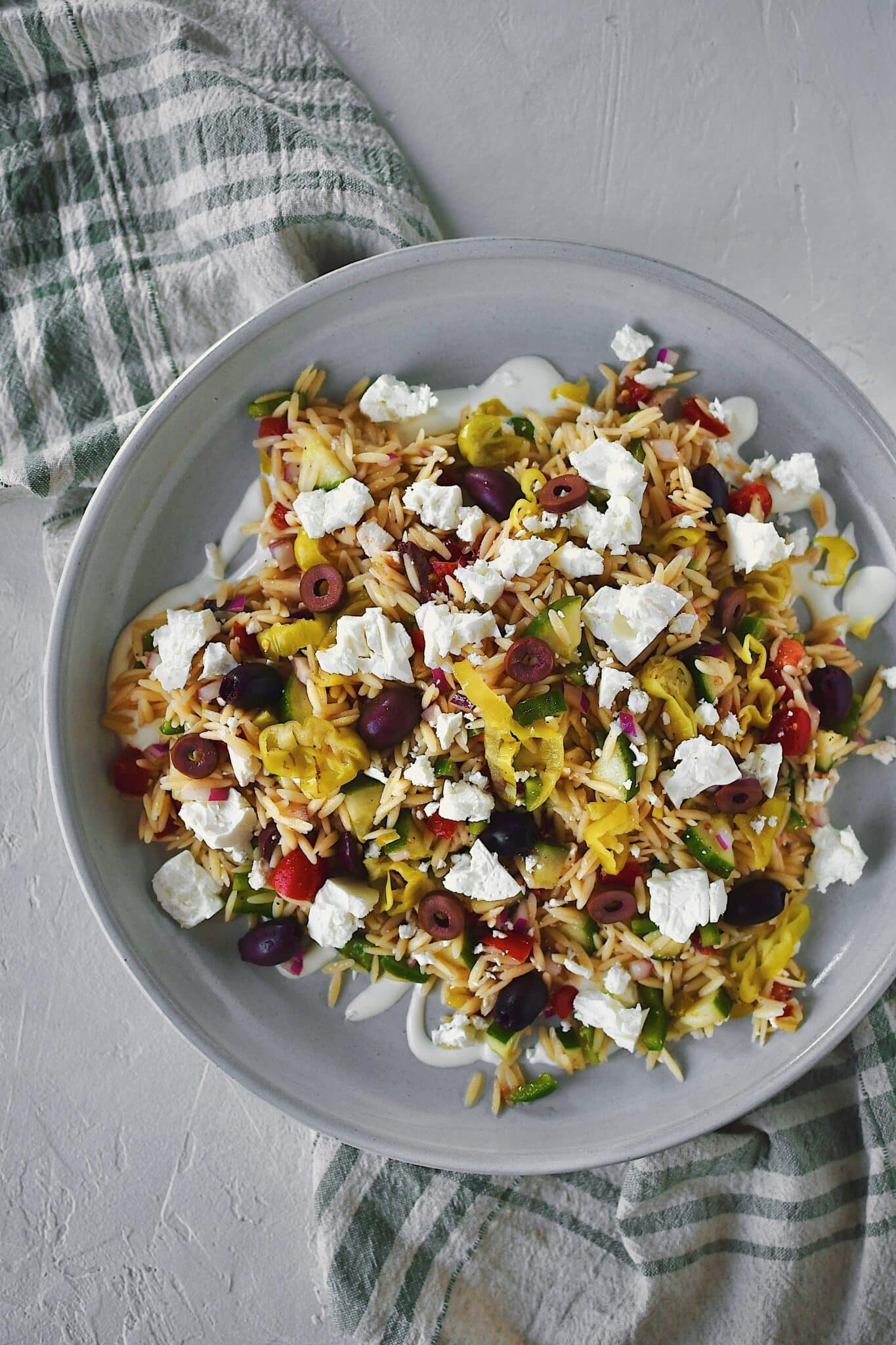 Greek Pasta Salad on a platter, topped with extra feta, ready to be enjoyed!