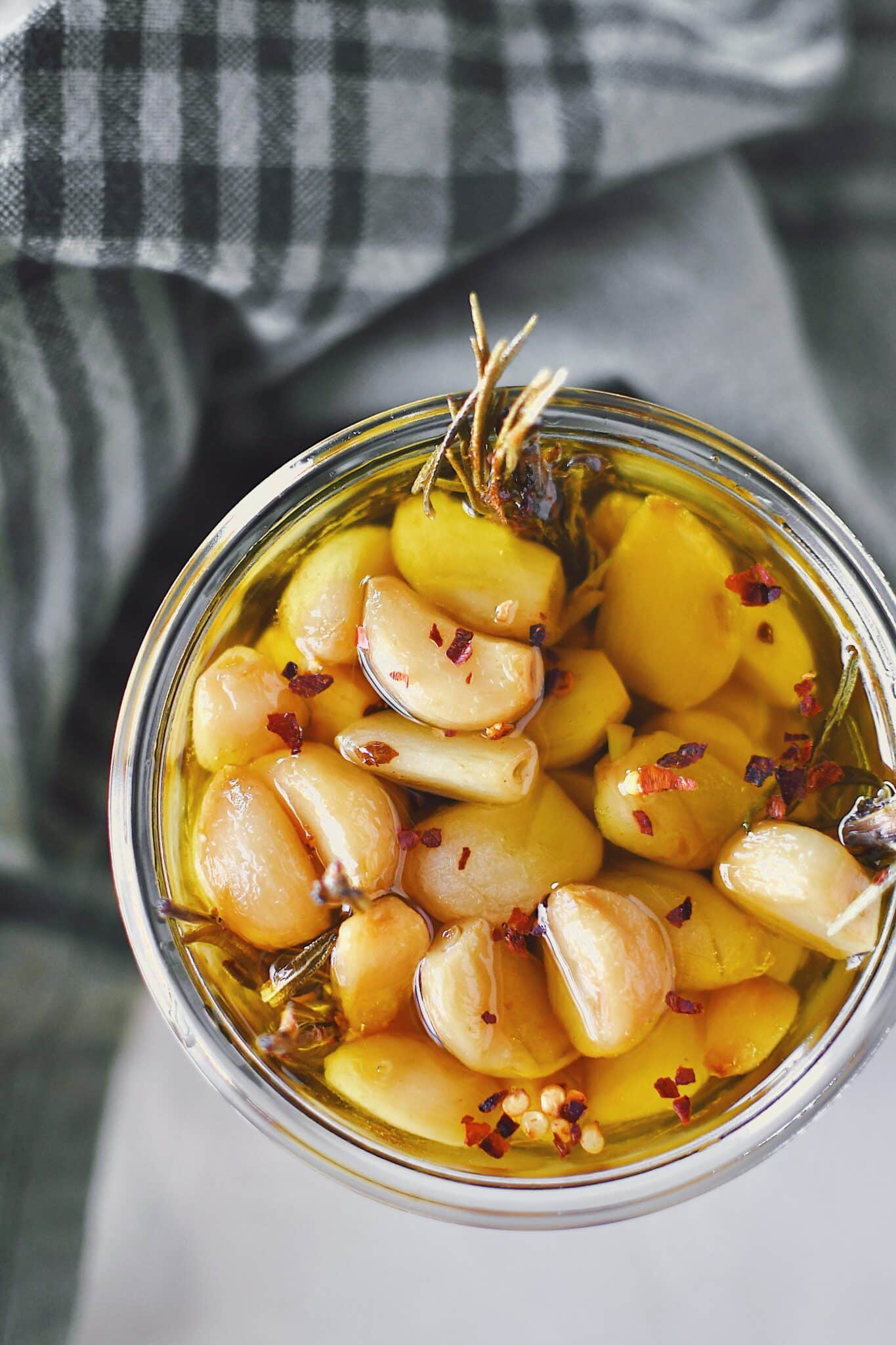 Garlic Confit in a jar covered with olive oil, ready to eat.