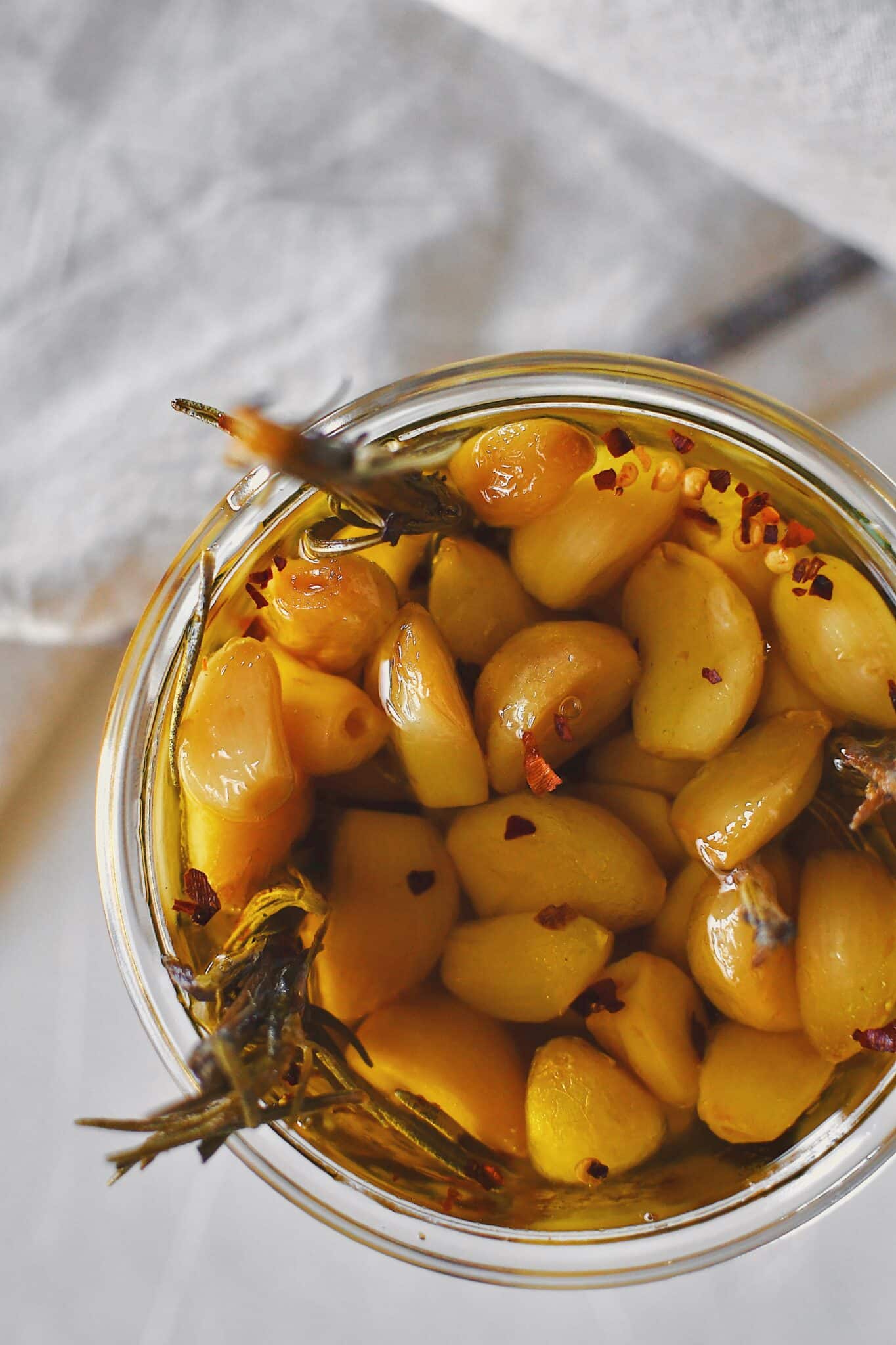 Garlic Confit in a jar covered with olive oil, ready to eat.