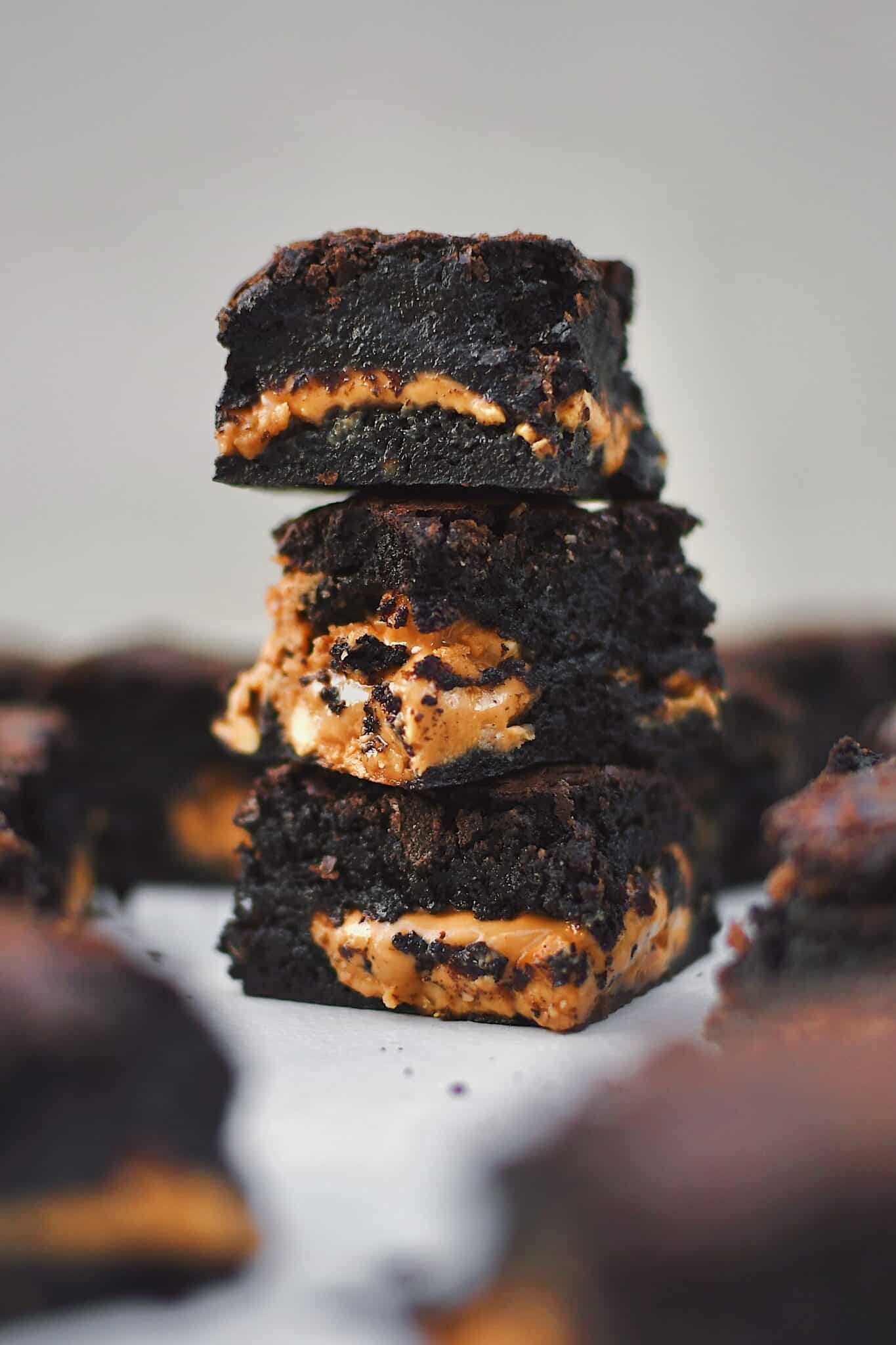 Peanut Butter Brownies stacked and scattered on a platter, cut and ready to eat.