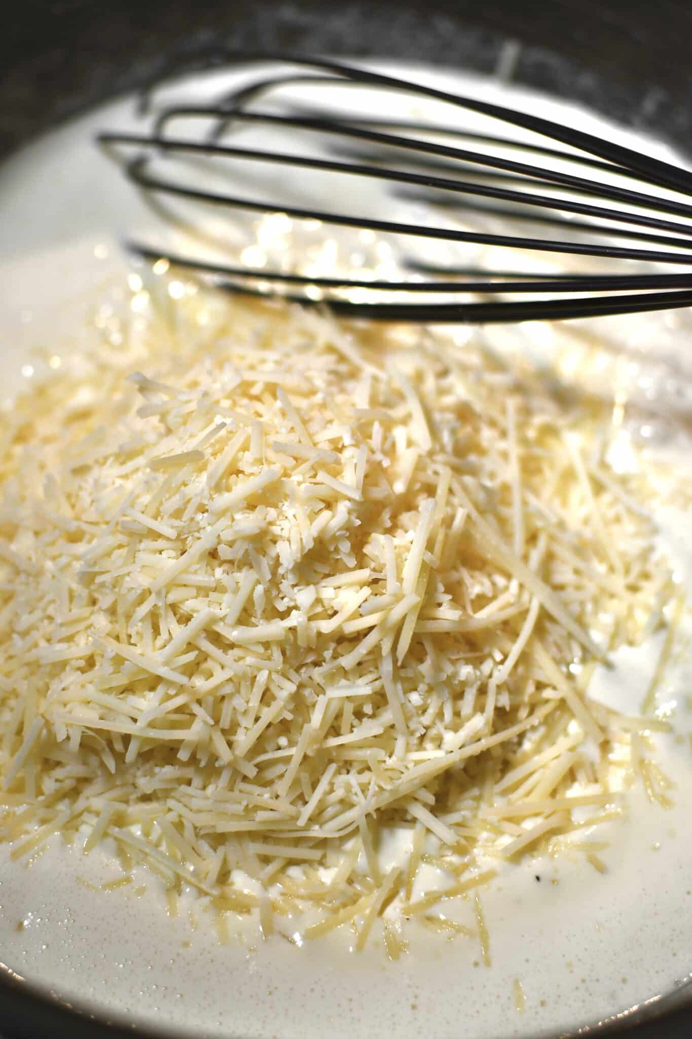 Adding the parmesan cheese to reduced cream.