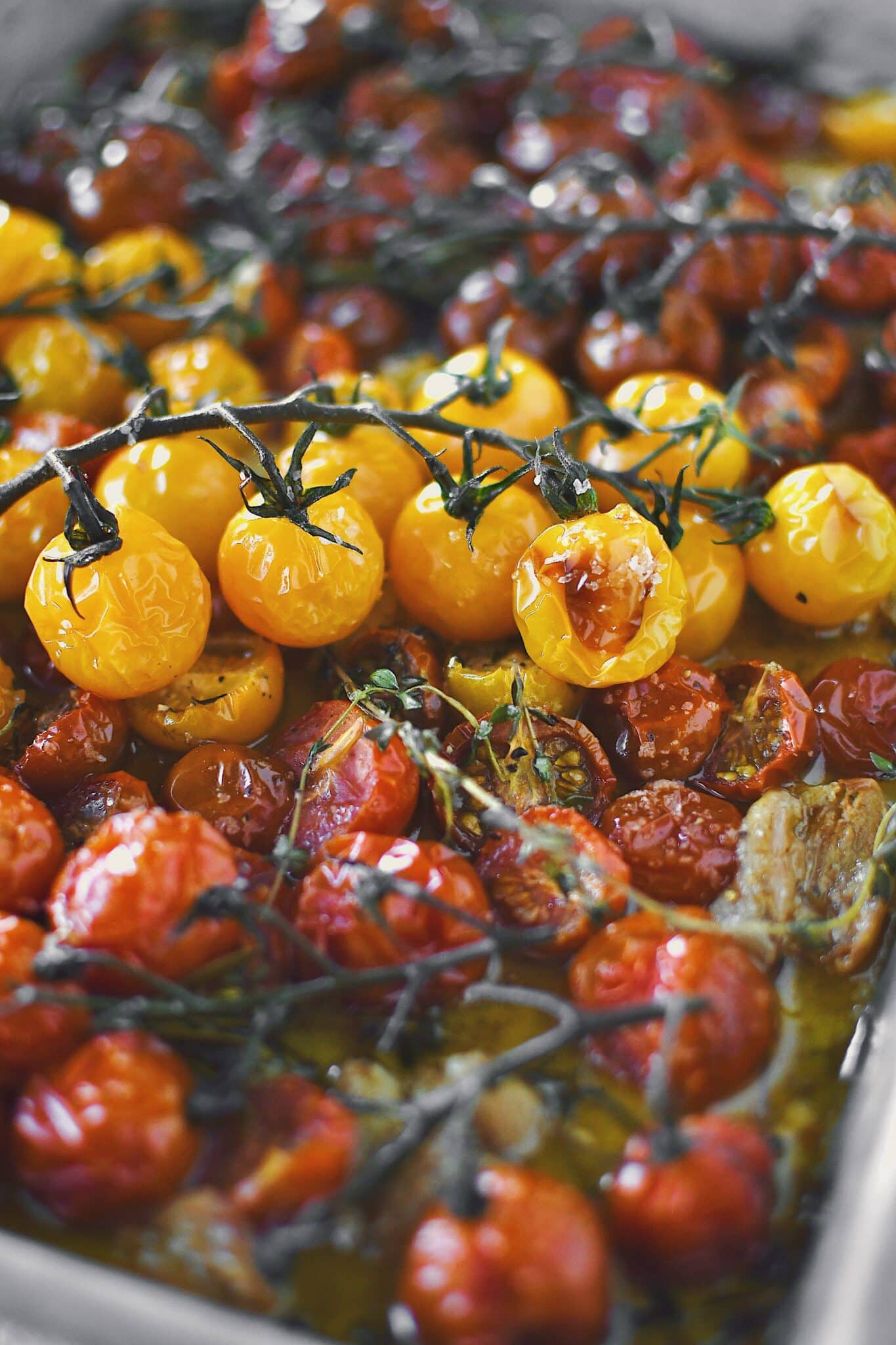 Seasoned cherry tomatoes, garlic, and herbs, after roasting.