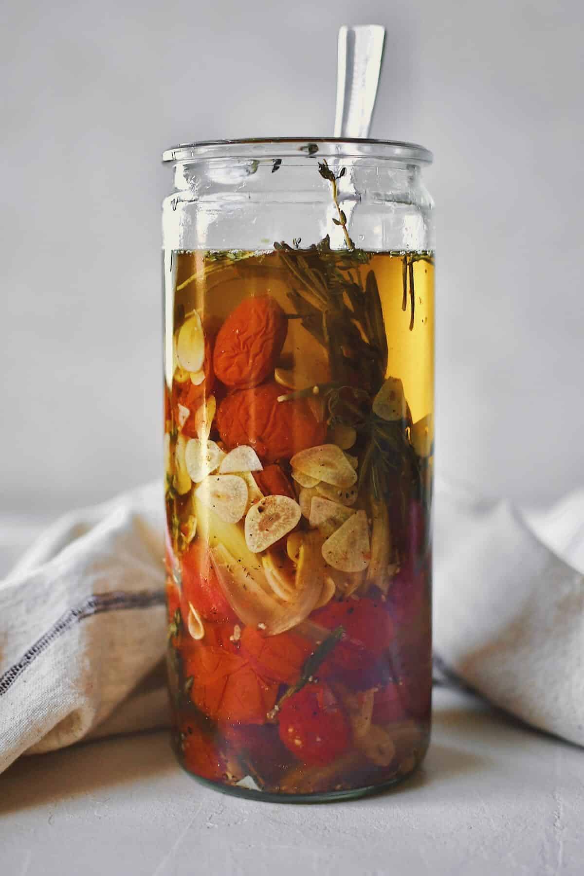 Tomato Confit in a jar covered in oil, ready to be stored.