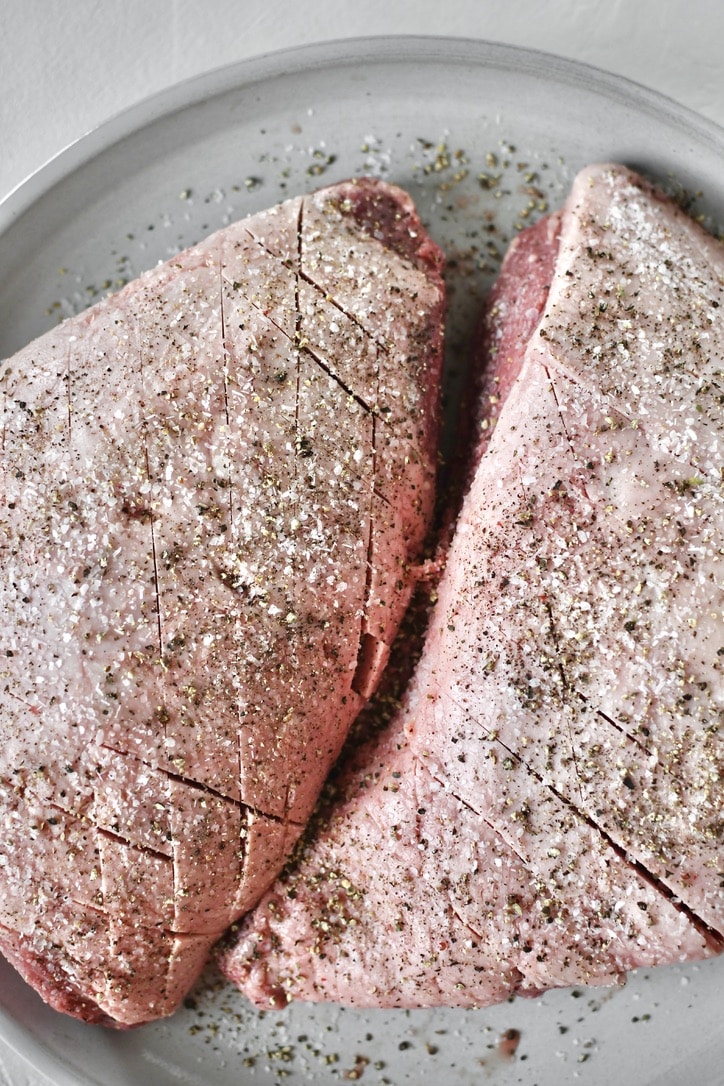 Seasoned beef resting at room temperature.