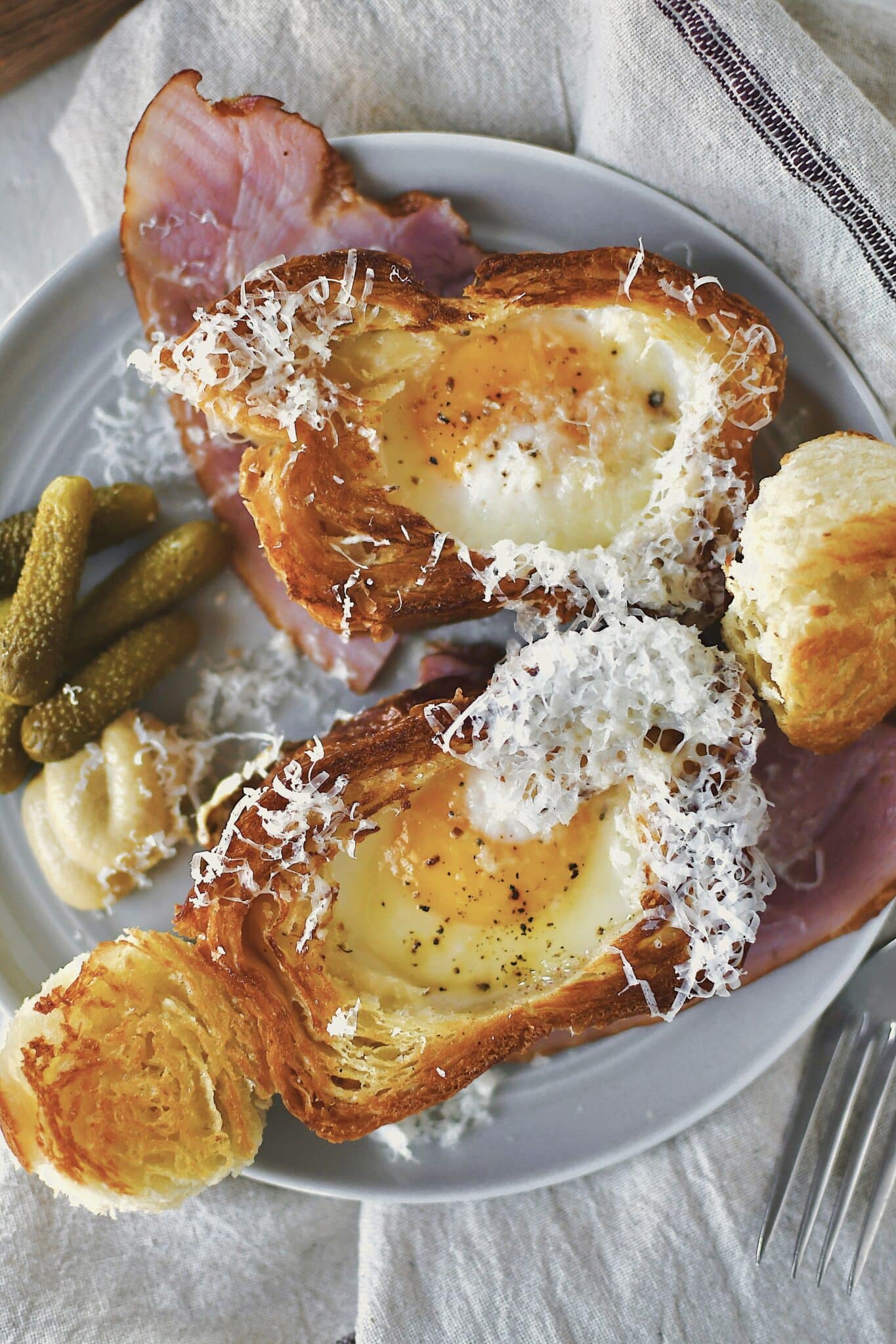 Eggs in a Basket served over a ham steak and topped with gruyere cheese.