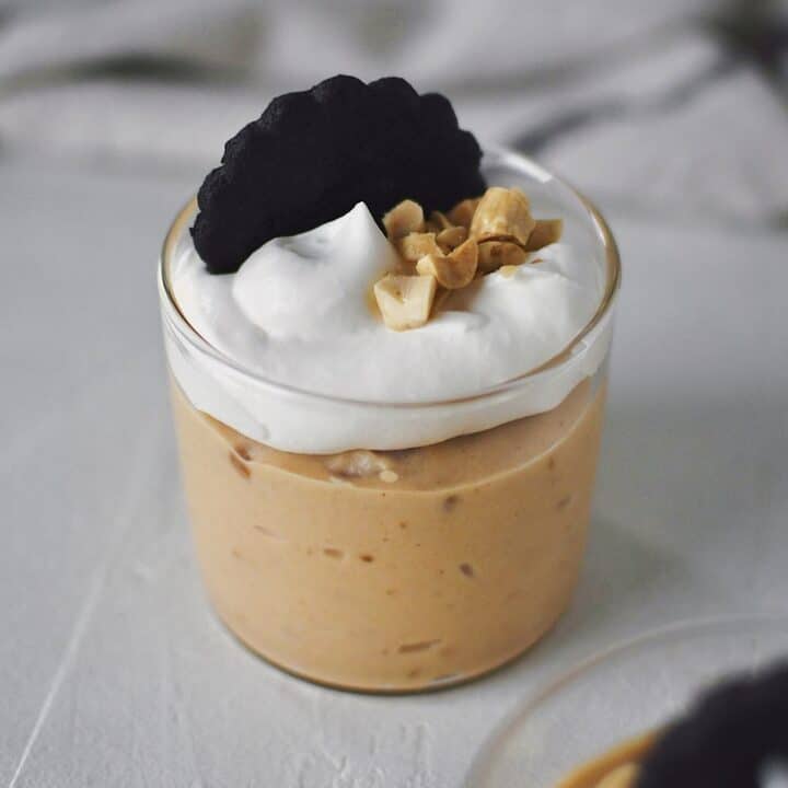 Peanut Butter Mousse in a small cup, topped with whipped cream, peanuts, and a chocolate wafer.