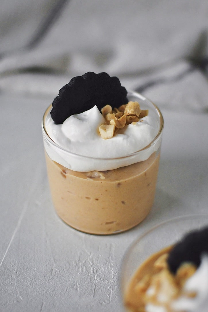 Peanut Butter Mousse in a small cup, topped with whipped cream, peanuts, and a chocolate wafer.