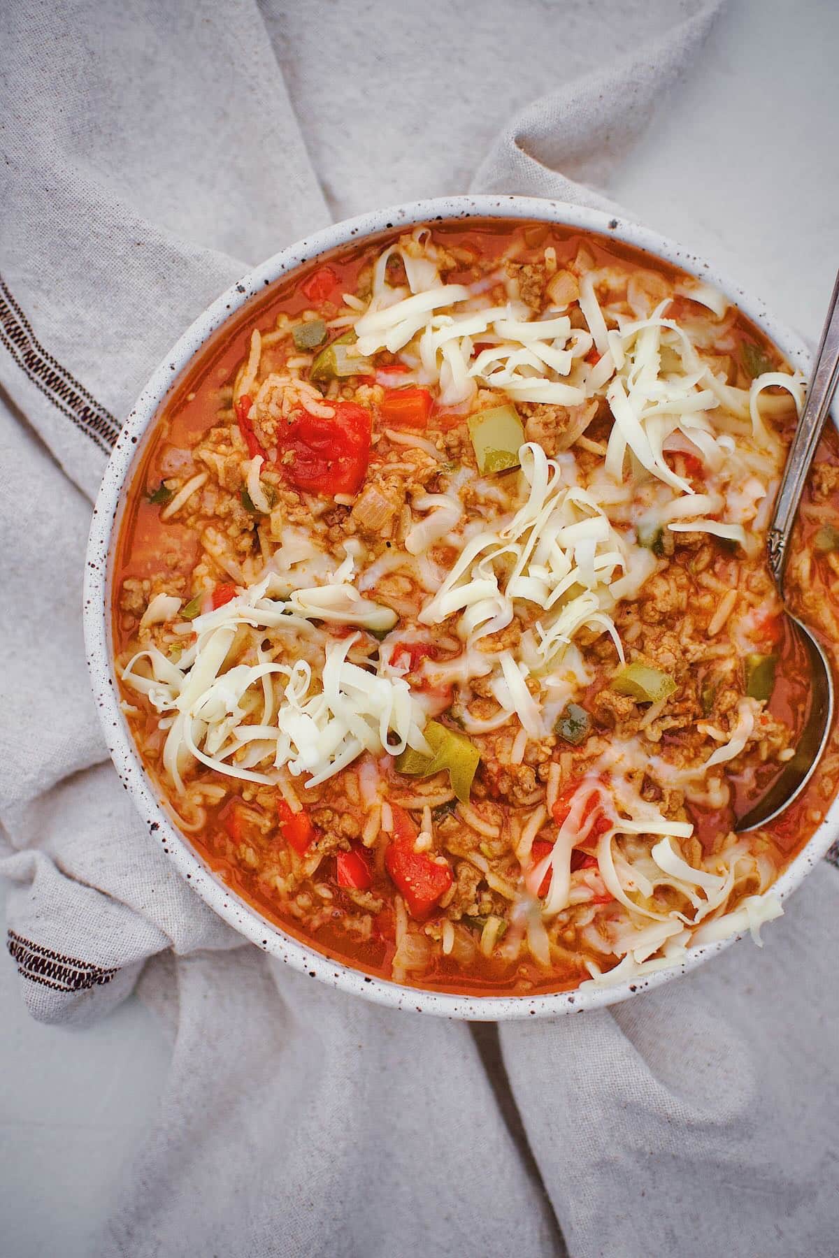 Stuffed Pepper Soup in a bowl topped with pepper jack cheese ready to be eaten.