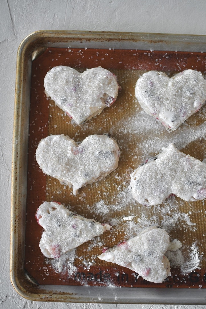 Chilled scones that have been cut in hearts, and brushed with heavy cream and topped with sanding sugar.