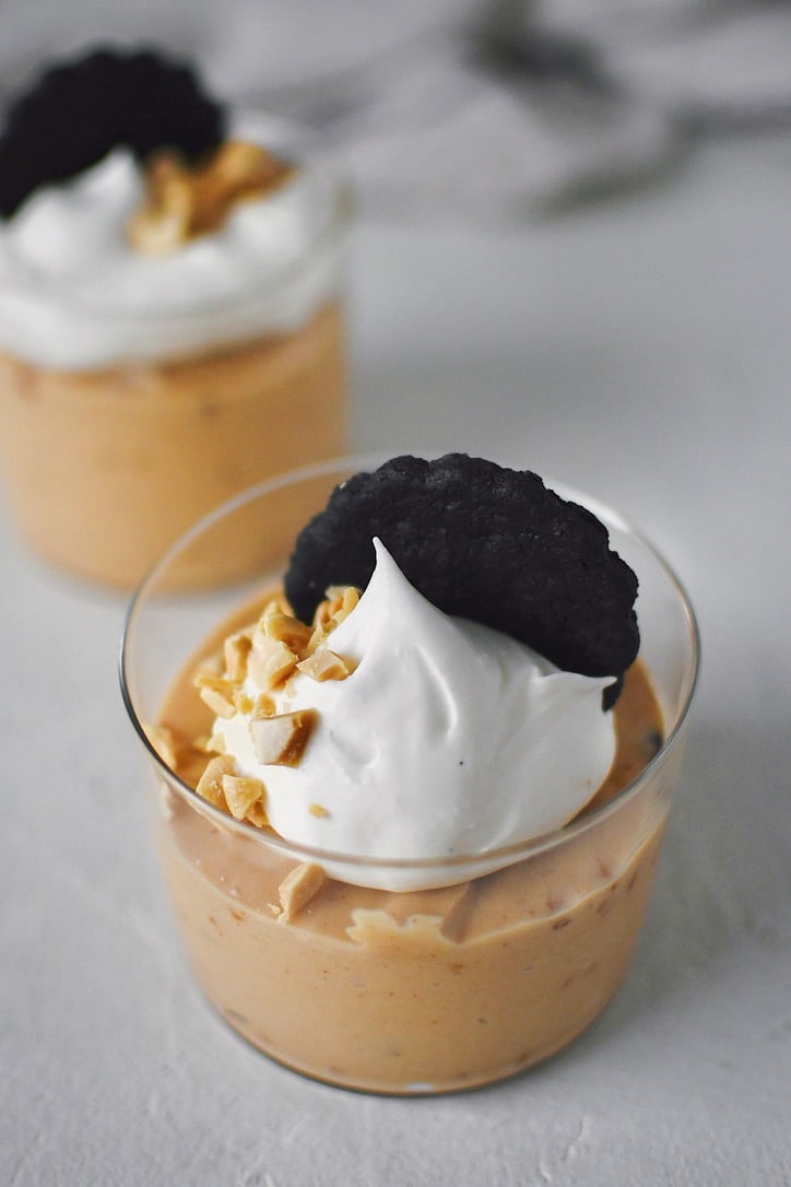 Peanut Butter Mousse in a small cup, topped with whipped cream, peanuts, and a chocolate wafer.