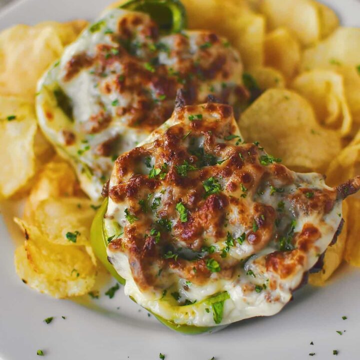 Philly Cheesesteak Stuffed Peppers on a plate ready to eat surrounded by potato chips.