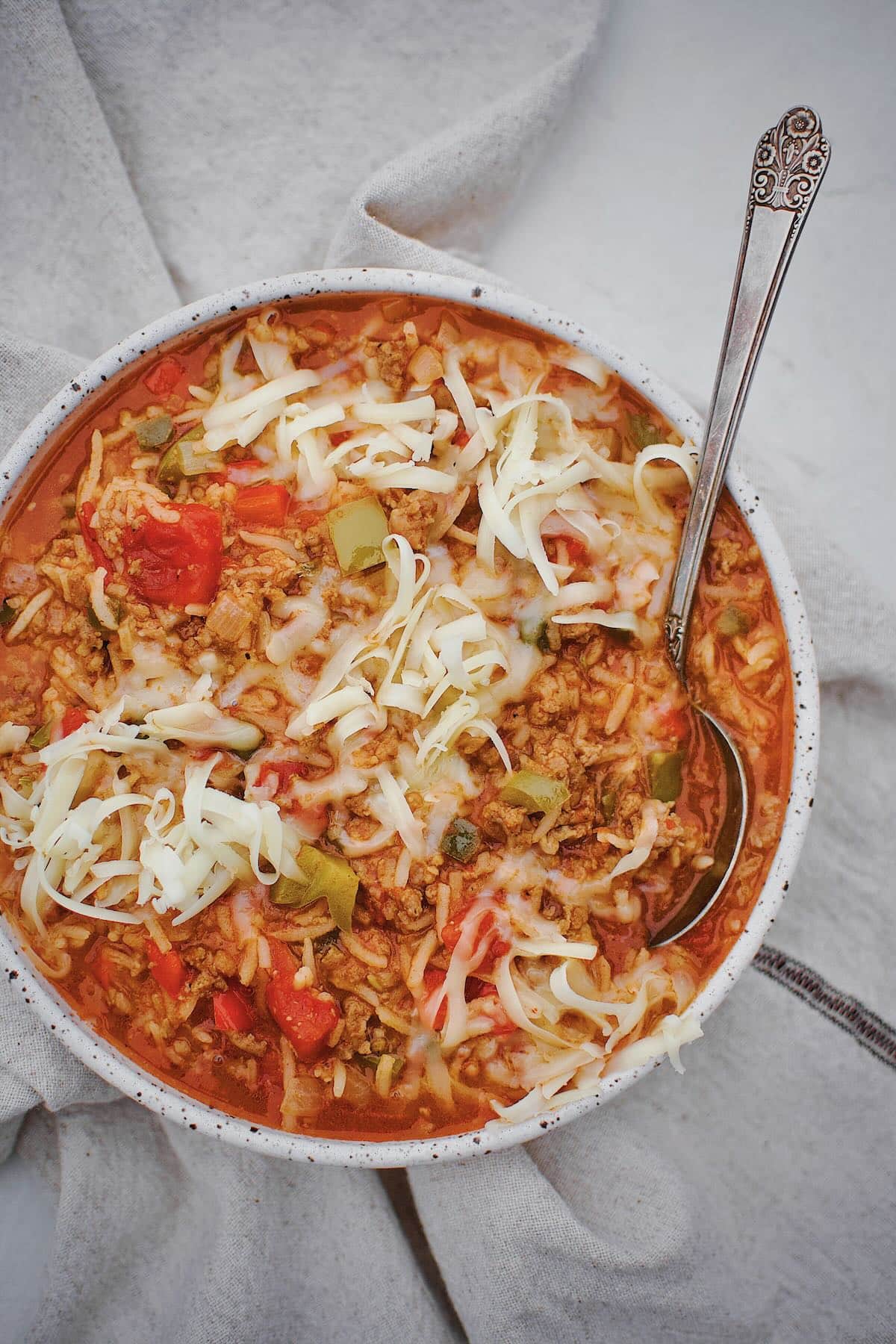 Stuffed Pepper Soup in a bowl topped with pepper jack cheese ready to be eaten.