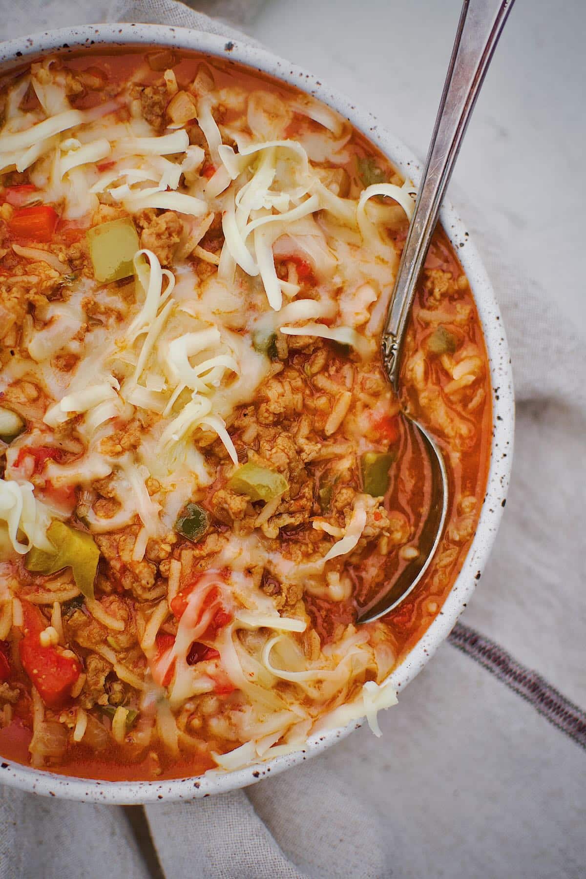 Stuffed Pepper Soup in a bowl topped with pepper jack cheese ready to be eaten.