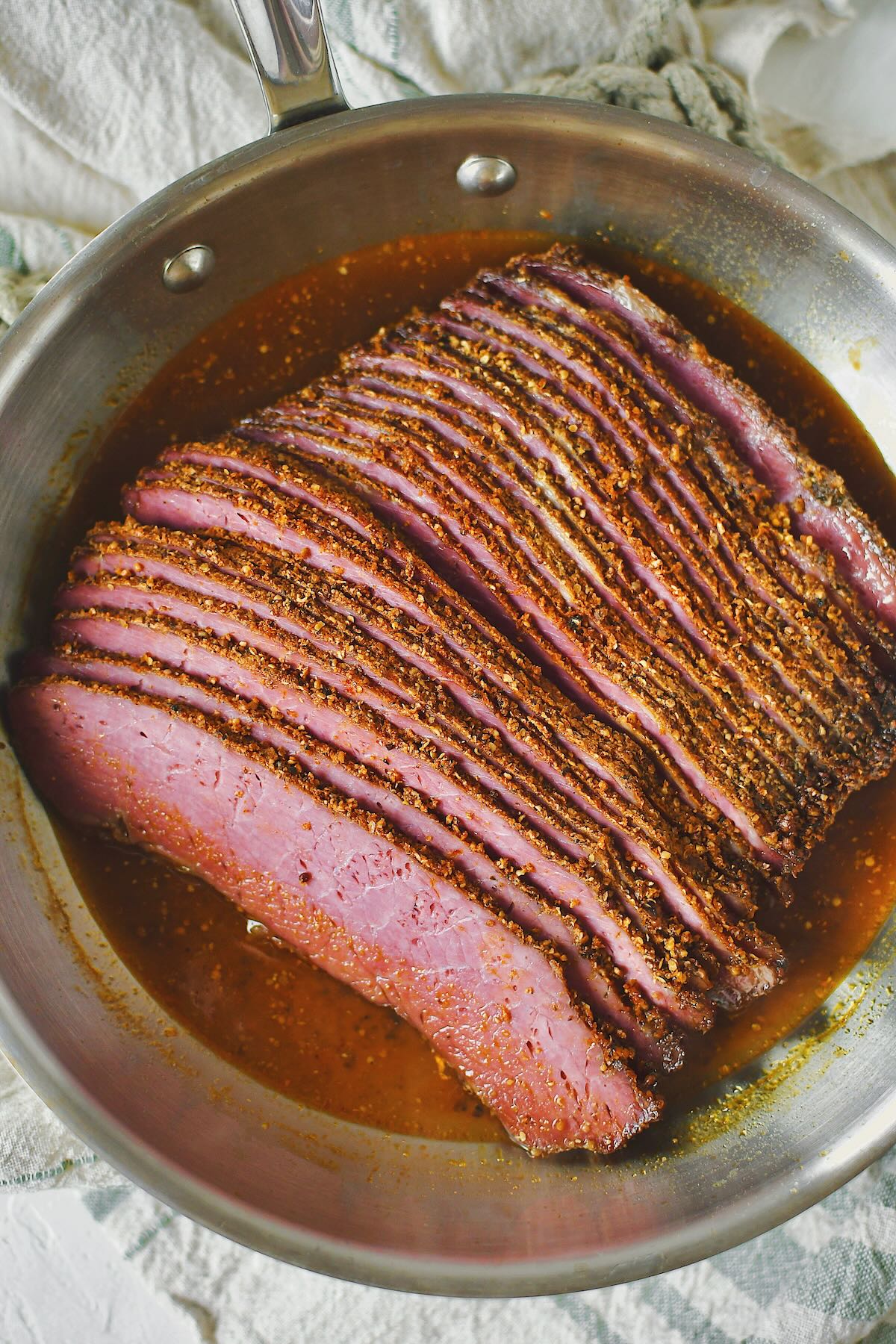 Reheating sliced pastrami in the juices that were saved from roasting.