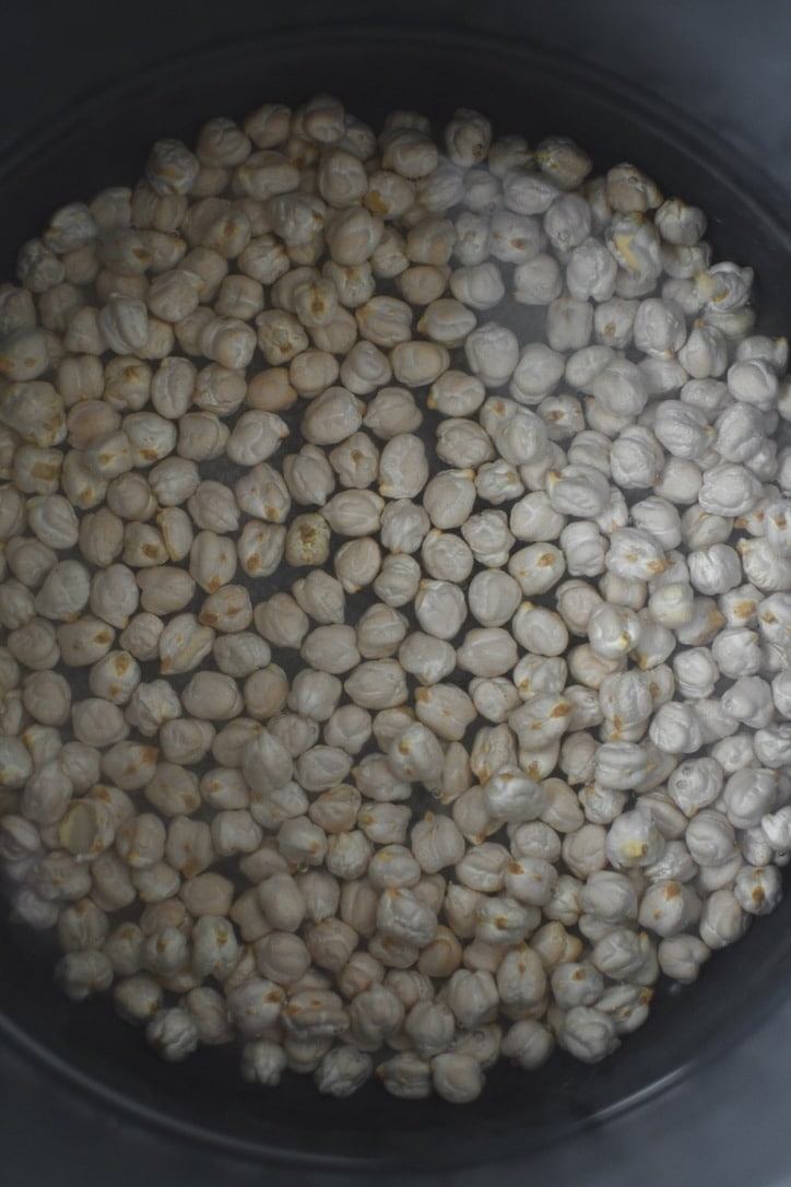 Dry chickpeas placed in the bowl of an instant pot covered with 2 inches of water, salt added.