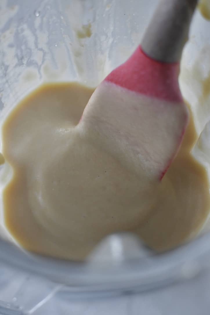Chickpeas in a high speed blender that have been pureed to a smooth paste.