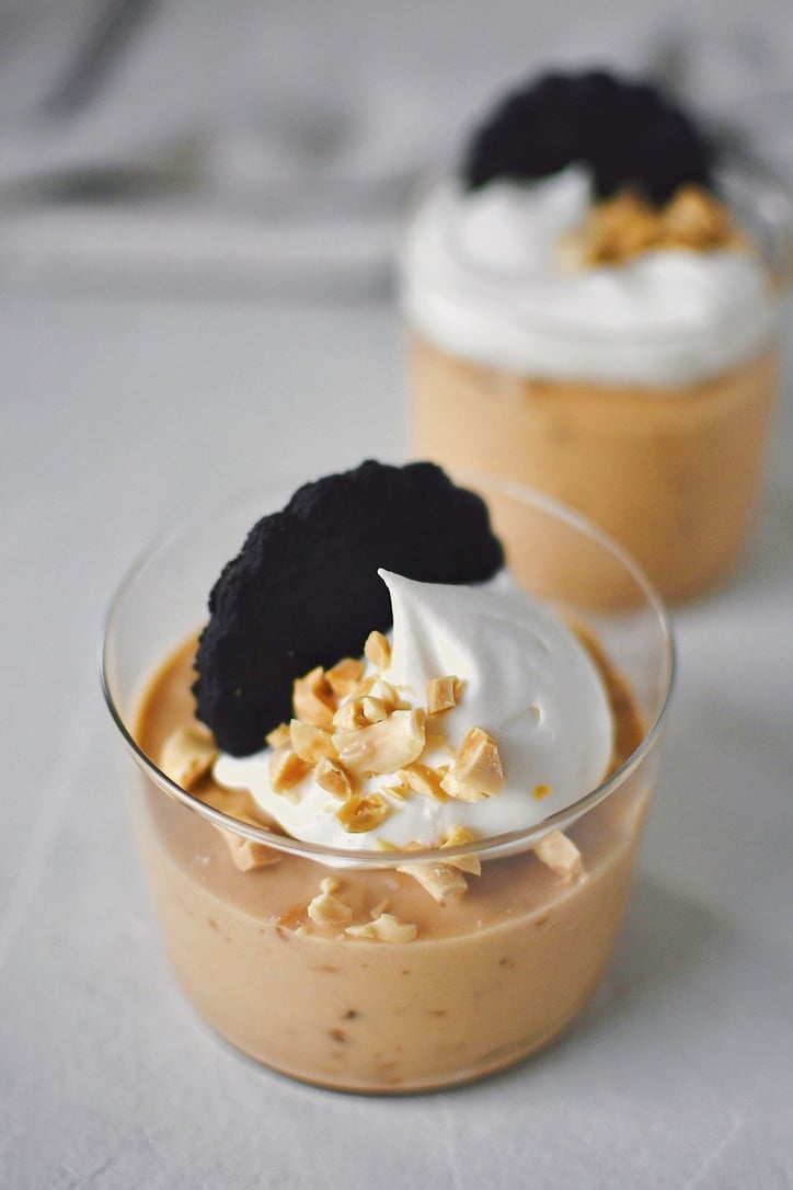 Peanut Butter Mousse in a small cup, topped with whipped cream, peanuts, and a chocolate wafer.