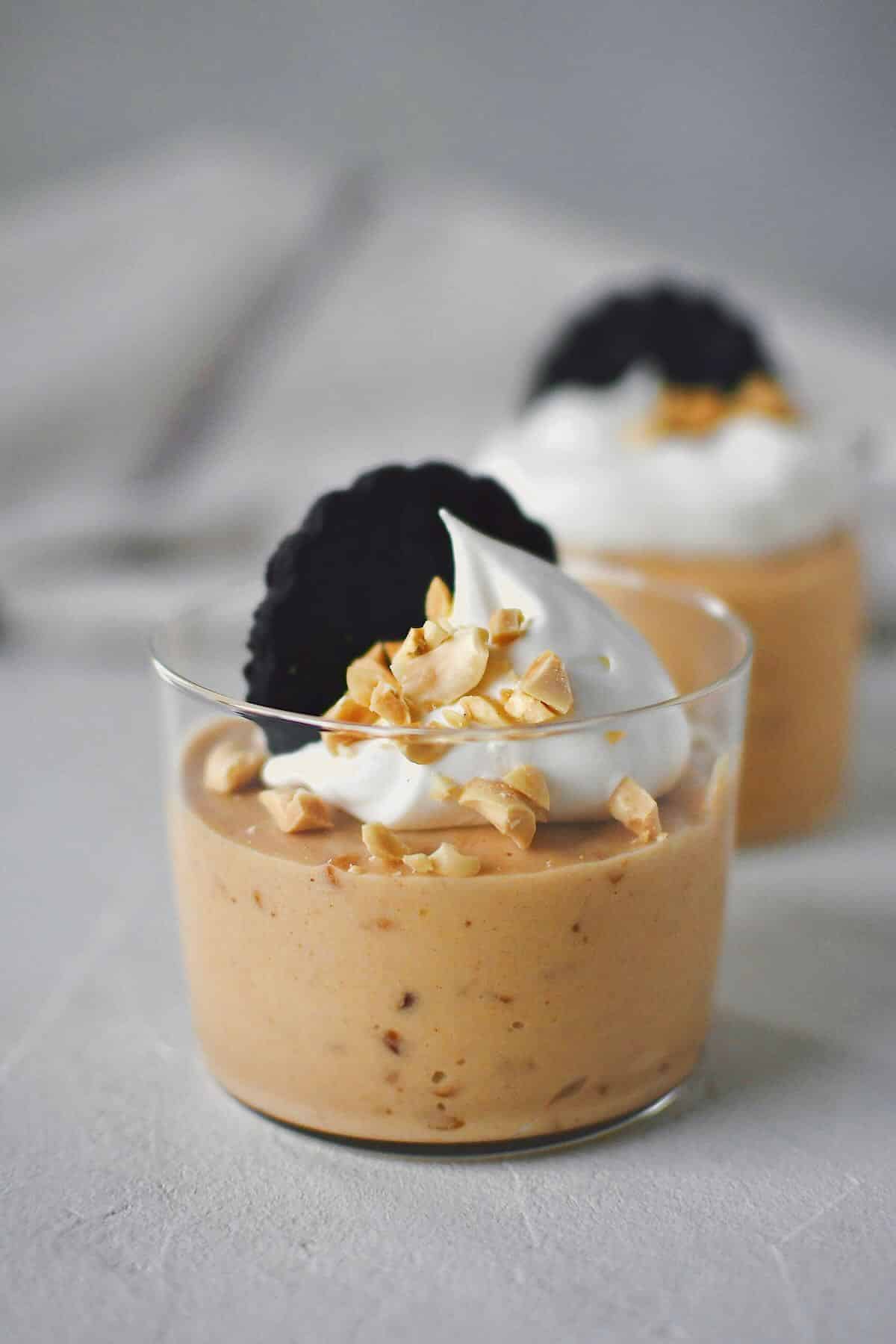 Peanut Butter Mousse in a small cup, topped with whipped cream, peanuts, and a chocolate wafer.
