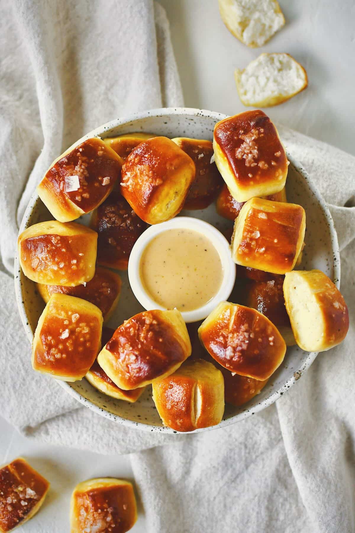 Homemade Pretzel Bites on a platter with cheese sauce in the middle for dipping.