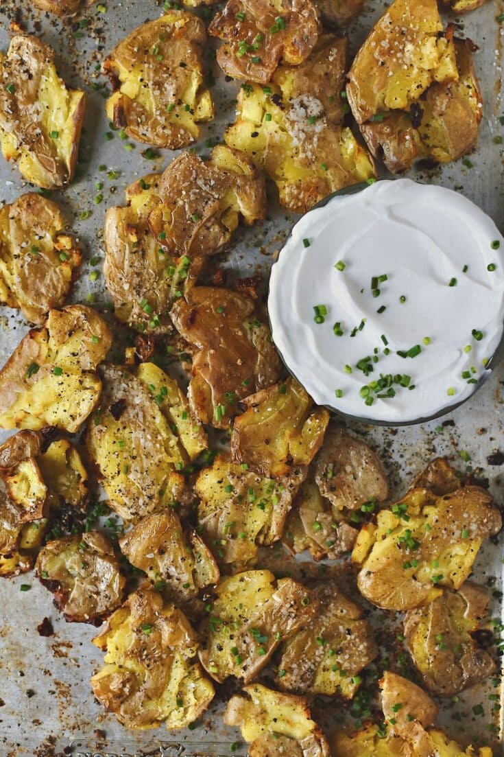 Crispy Smashed Potatoes just out of the oven ready to be enjoyed with some chive sour cream on the side.