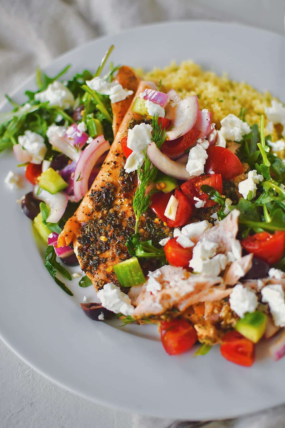 Greek Salmon topped with Greek salad topping of fresh veggies and feta cheese.
