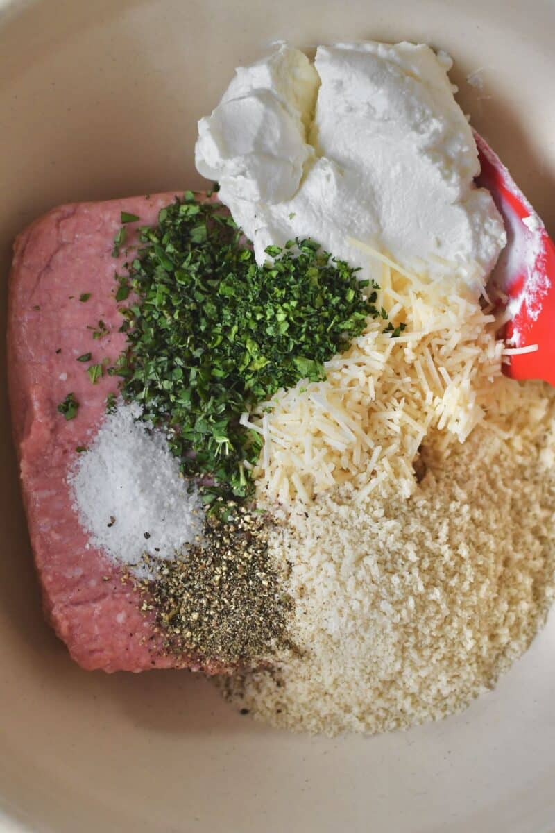 Placing all the ingredients into a bowl to form the burger patties.